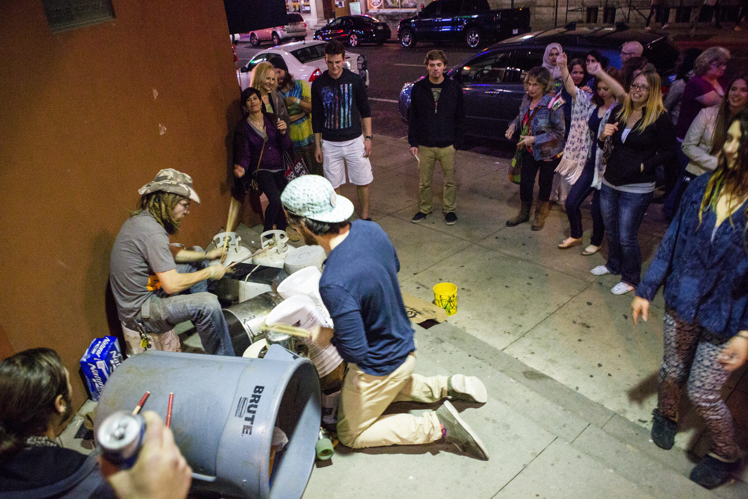  A student joins in drumming as Spiral plays the bucket drums on Court Street in Athens, Ohio. While they didn't garner much attention at first, soon Spiral and his friends' playing garnered a small, energetic crowd. They made over $100, as it was mo