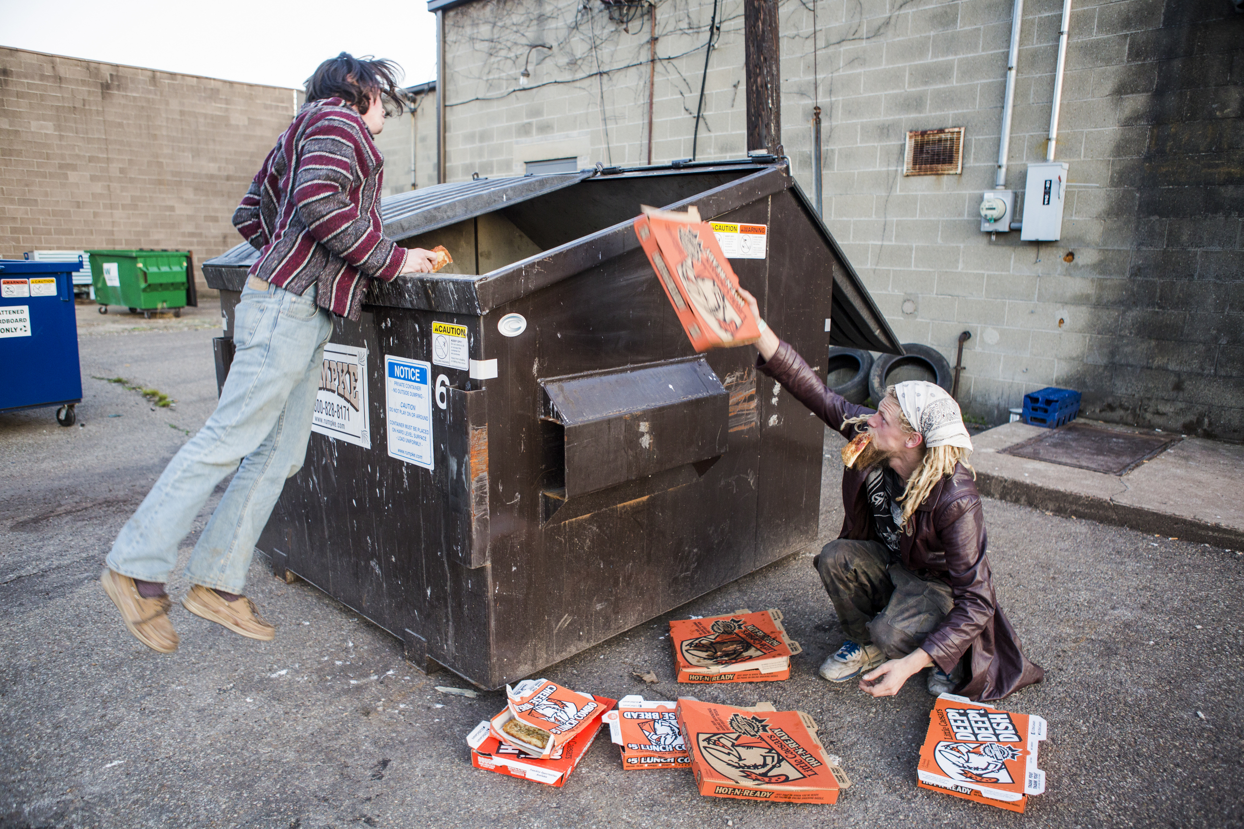  Riley Gates, left, and Solar, right, dumpster dive for Little Caesers pizza behind the shop in Athens, Ohio. The travelers don't stop at typical restaurants or grocery stores for food, but find most of it by dumpster diving and finding food. Their t