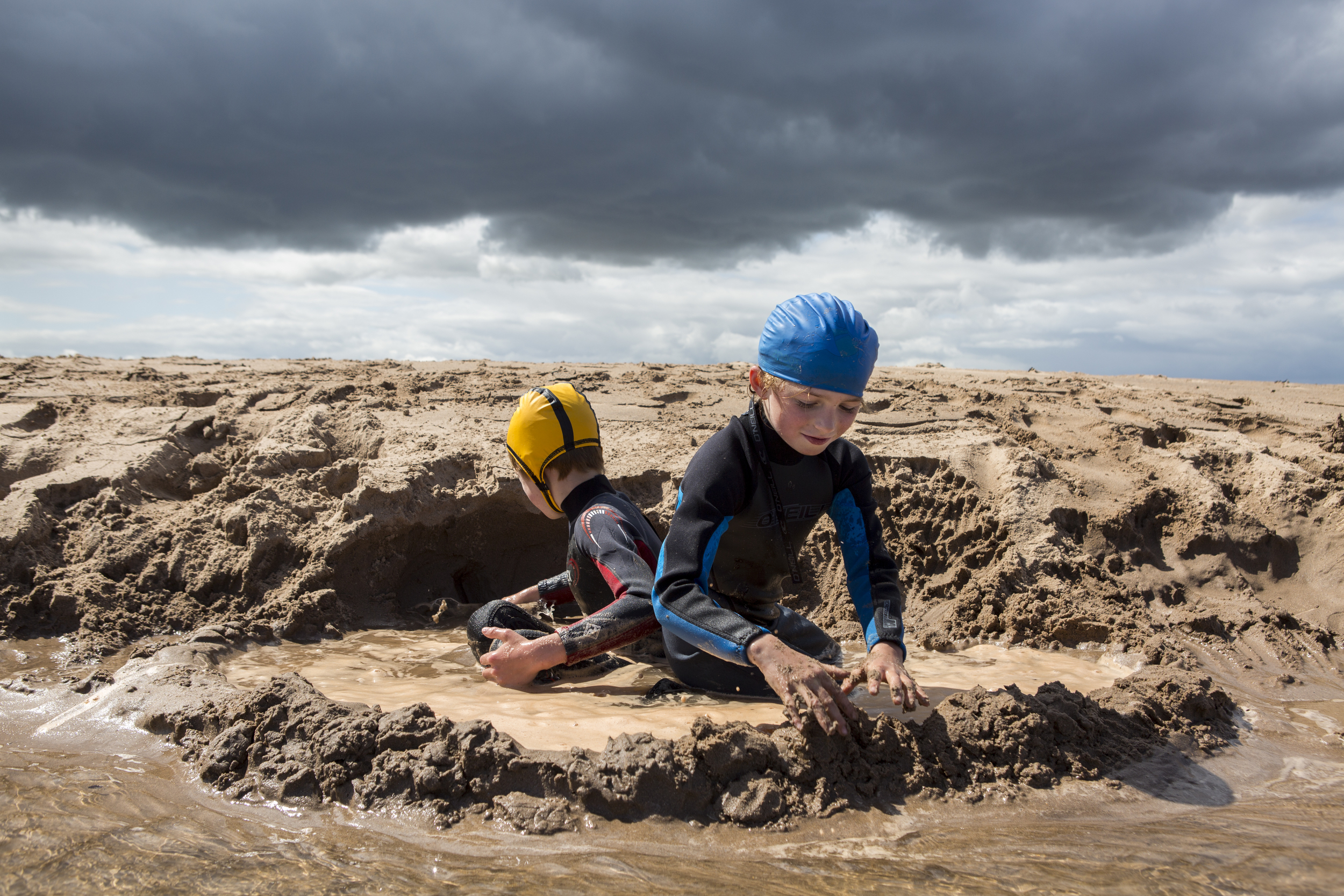 Frayja, 7, and Fergus Hawson, 10, enjoy time playing with sand in Dunbar, Scotland, as rain clouds move in on July 23, 2015. They joined their parents Tom and Jenny, and their dog Beattie, on a sailing vacation along the Scotland coast.