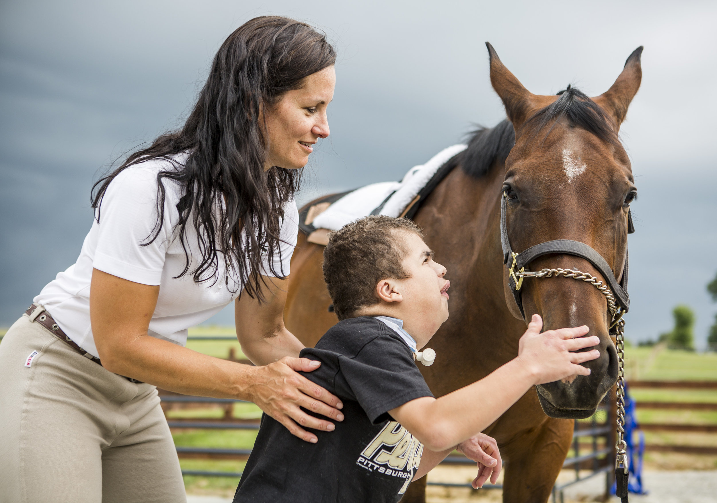  Mason Markosky pets Sleepy the horse after riding while being held by his mother Catherine, owner of Southern Tier Alternative Therapies (STAT), at the Ligonier Theraputic Center in Cook Township, Pennsylvania, on Monday, July 18, 2016. Mason has a 