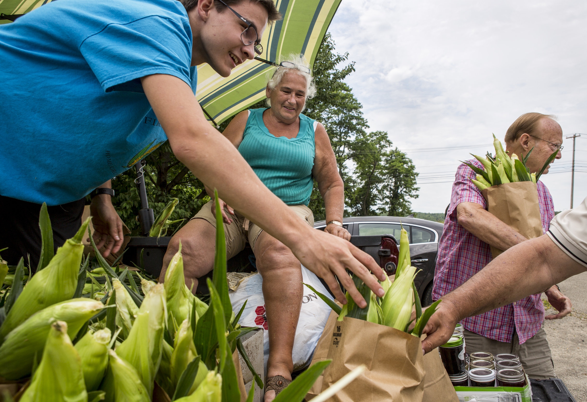 Rita Firestone of Greensburg and her assistant of four years, Jacob Porch, sell corn to customers along Route 30 in Latrobe, Pennsylvania, on Friday, July 1, 2016. Firestone has been selling corn, flowers, pumpkins and the like at the same spot for 46 years.