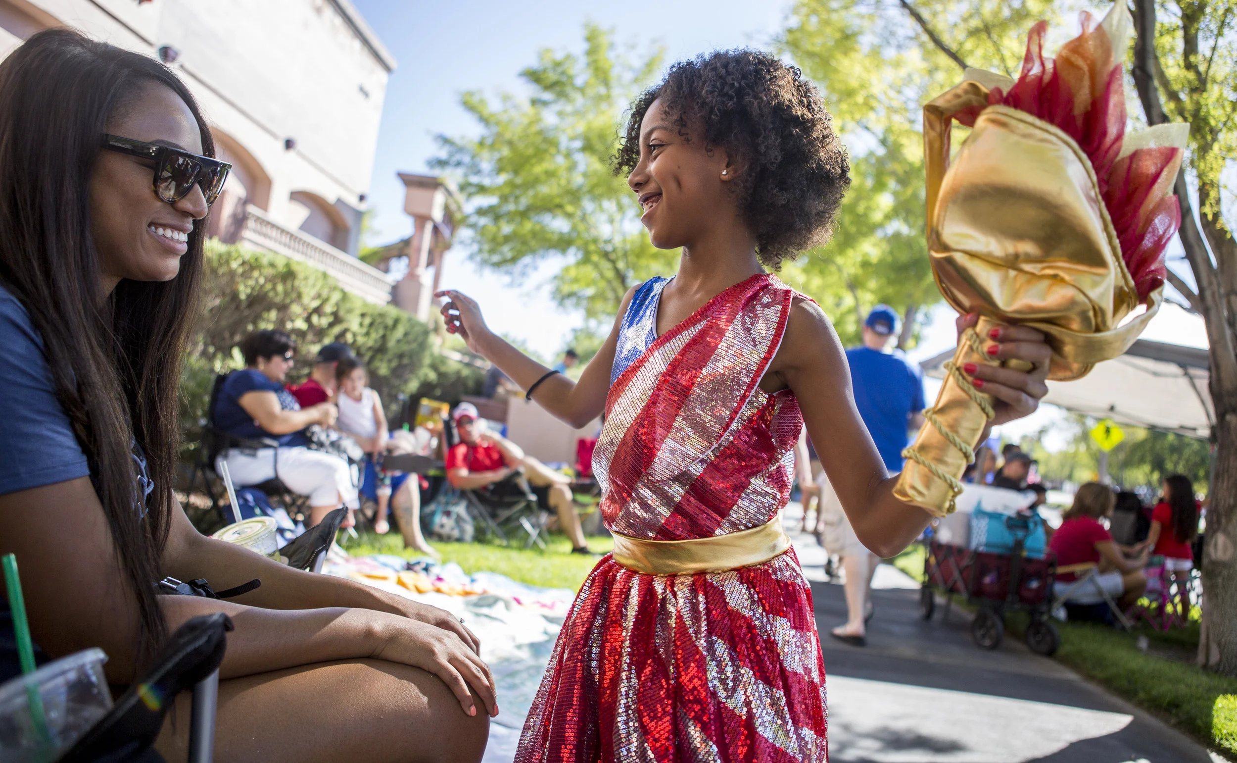 Brooklynn Winslow, 8, shows off her sparkly American flag dress and torch while her mother Natalie Winslow smiles during the Summerlin Council Patriotic Parade in Summerlin, outside of Las Vegas, on Tuesday, July 4, 2017.