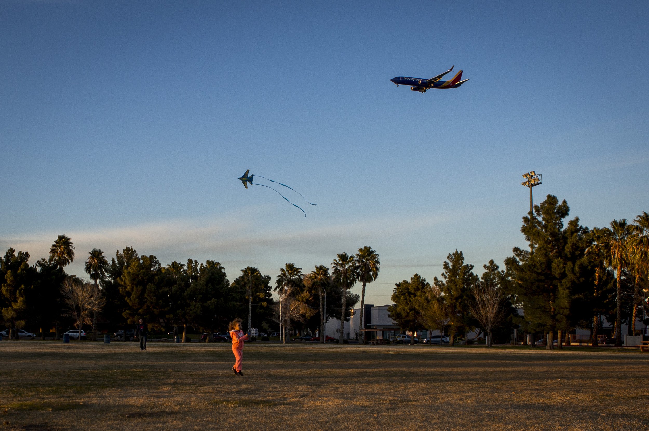  Las Vegas resident Arayah Murray, 5, flies her airplane kite as a real plane flies overhead during a breezy late afternoon in Sunset Park in Las Vegas. 