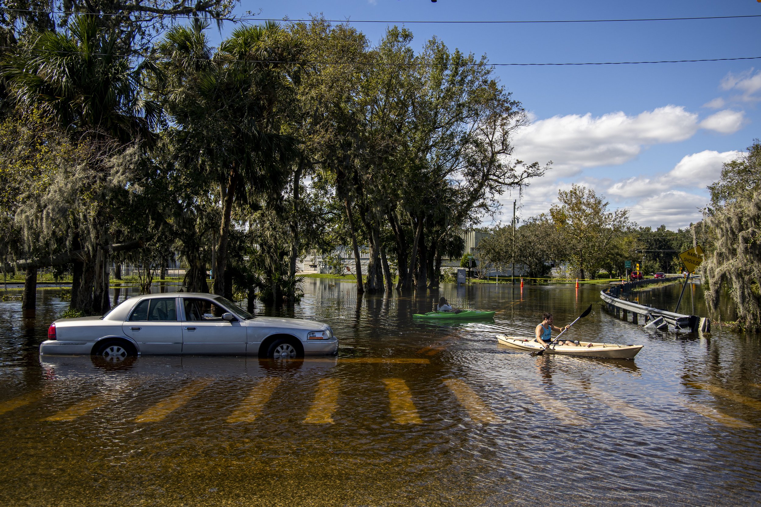  Jordan Kell, left, and Skylar Clemens work on kayaking to Clemens’ flooded apartment next to a stalled car near Dunlawton Avenue in Port Orange on Friday, Sept. 30, 2022, directly after Hurricane Ian swept across the Florida Peninsula. 