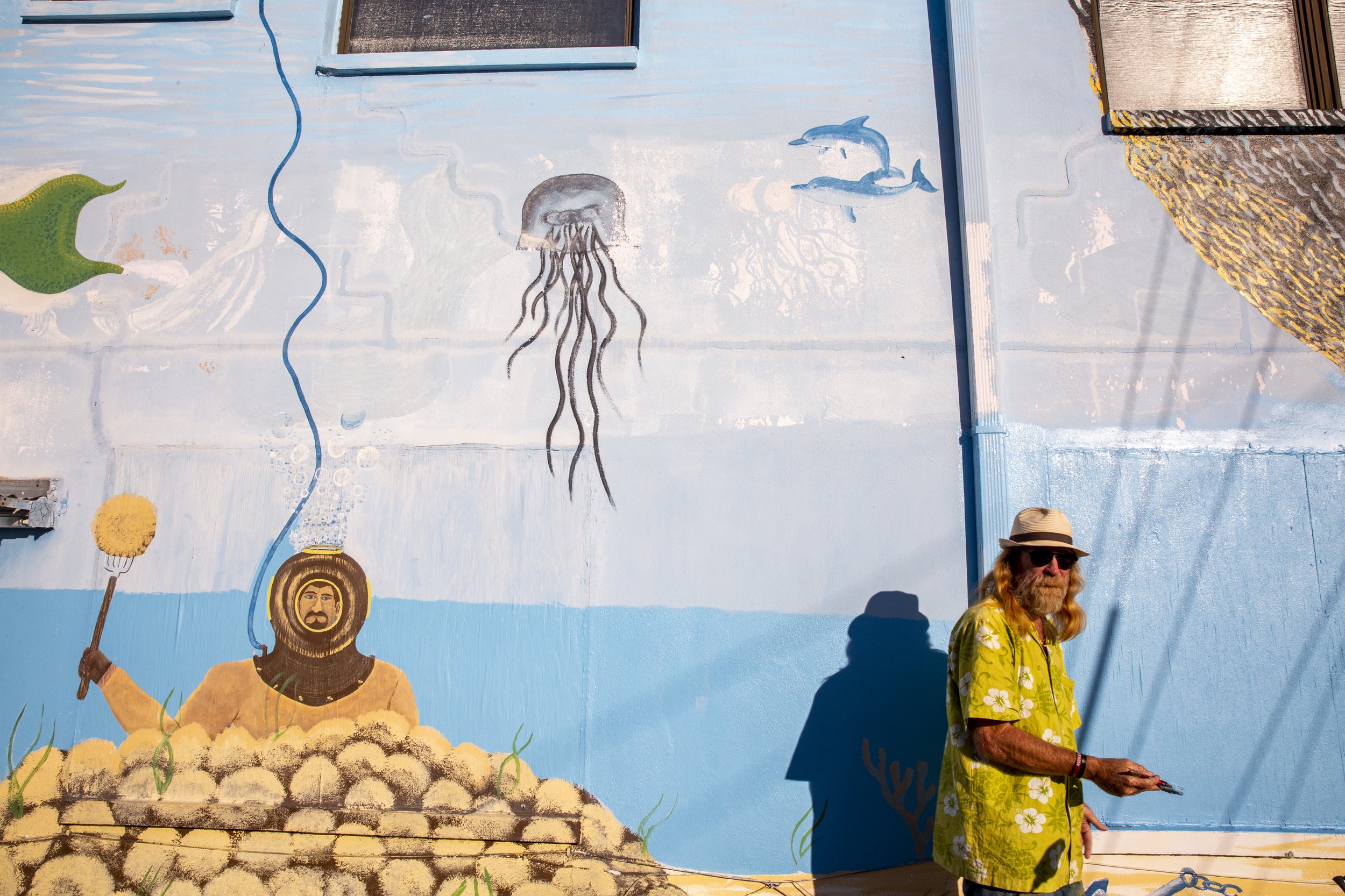  Local artist Mark DiClemente touches up a mural he first painted about 10 years ago in Tarpon Springs on Saturday, Dec. 19, 2020.  