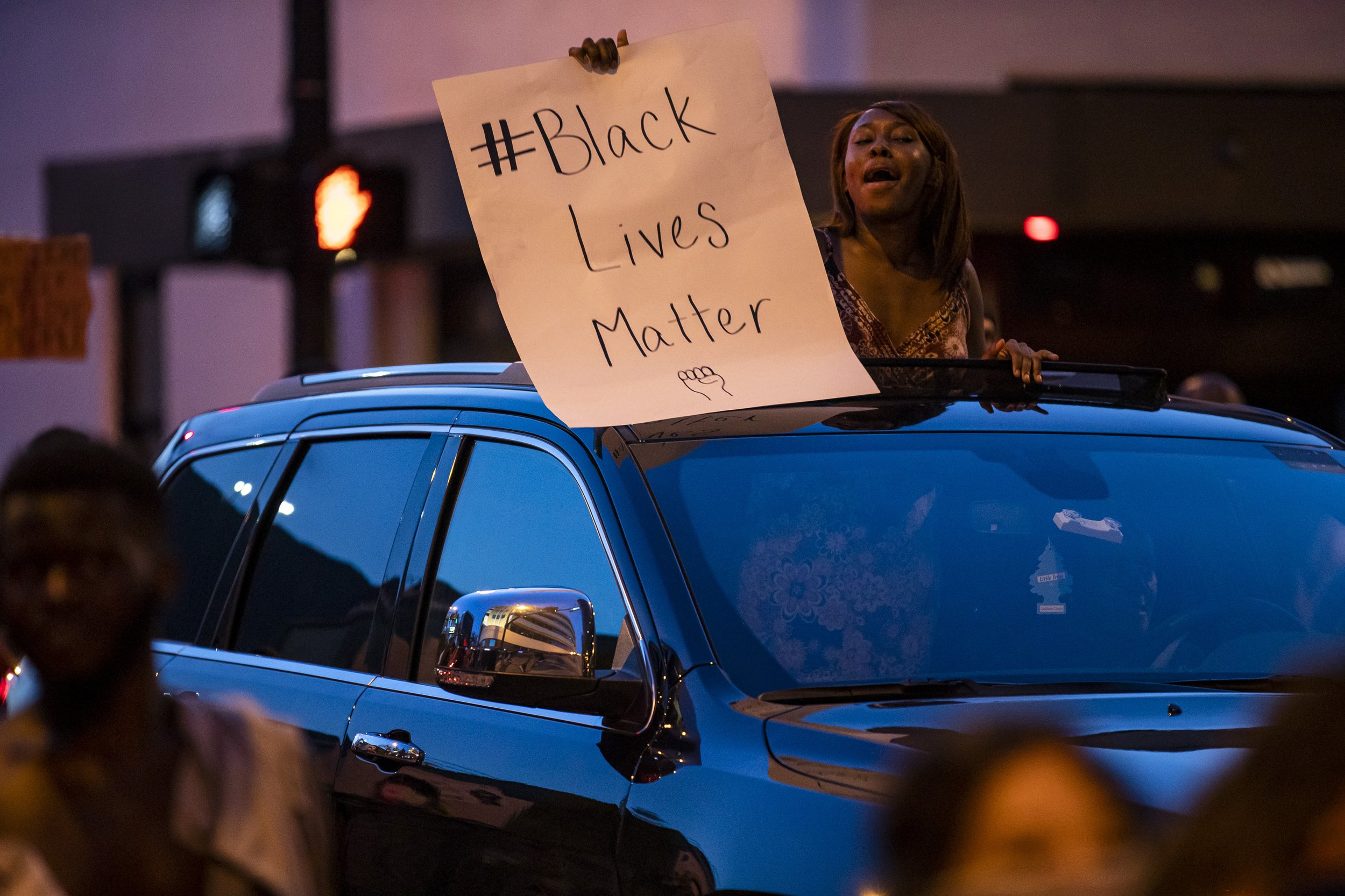  A woman holds a sign out of the sunroof of a car during a demonstration demanding justice for George Floyd in Orlando on Sunday, May 31, 2020. 