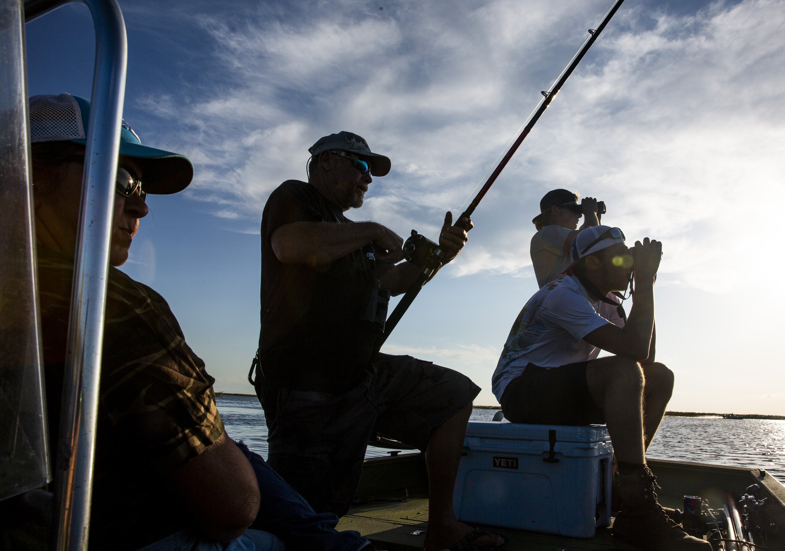  Capt. Bob Stafford, center, works on reeling in a fishing line during an alligator hunt with Okeechobee Charters on Lake Okeechobee Friday, Sept. 27, 2019. 