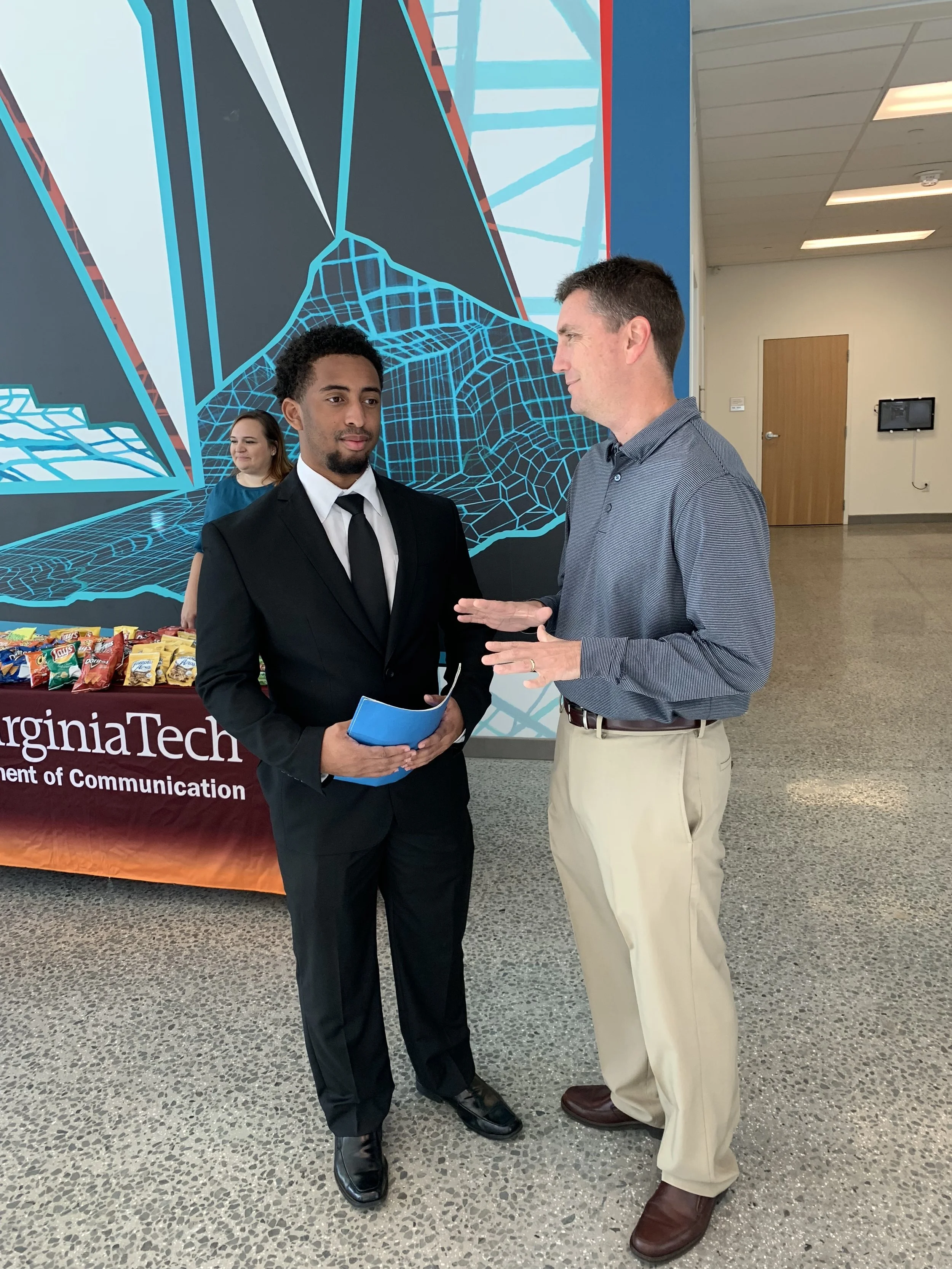 Sports Director Travis Wells of WDBJ-TV in Roanoke, Virginia visits with a Virginia Tech student at the Virginia Tech Communication Department 2018 Career Fair.