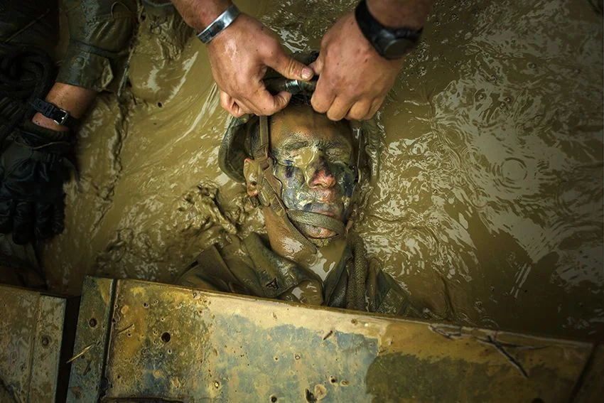 Hon. Mention in the Combat Training category: A Marine purses his eyes and lips shut as he is dragged from a mock booby trap in the “Pit and Pond” obstacle during the endurance course on April 19 at the Jungle Warfare Training Center, Okinawa, Japan. The endurance course is the final event Marines participating in jungle warfare training must face, trudging through roughly five miles of Okinawa jungle and 30 obstacles. Marines got creative in shuffling their squad mates beneath loose Plexiglas, avoiding contact with the “booby trap” at all costs. If any portion of the pane is touched, all Marines in a 5-meter radius are considered casualties and have to go back through the Pit and Pond. The Marines are with Company L, 3rd Battalion, 3rd Marine Regiment. The Hawaii-based battalion is attached to 4th Marine Regiment, 3rd Marine Division, III Marine Expeditionary Force as part of the unit deployment program. IMAGE: SGT. MATTHEW CALLAHAN, USMC