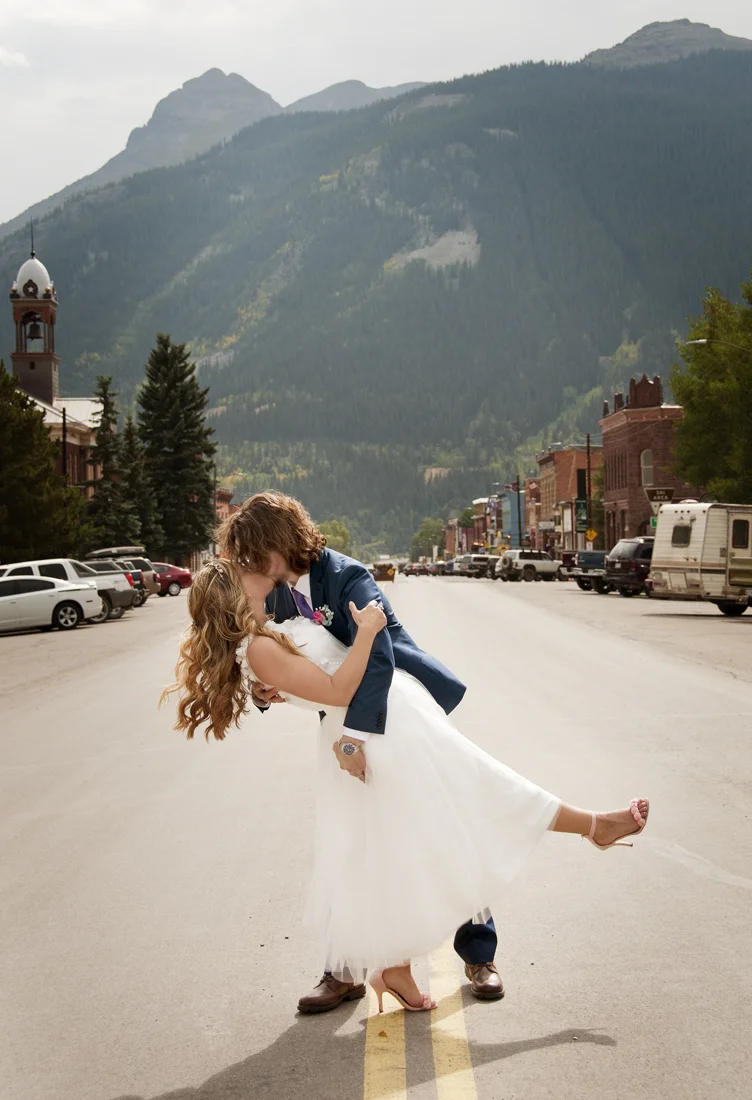 Groom dipping bride in road by photographers in durango co.jpg