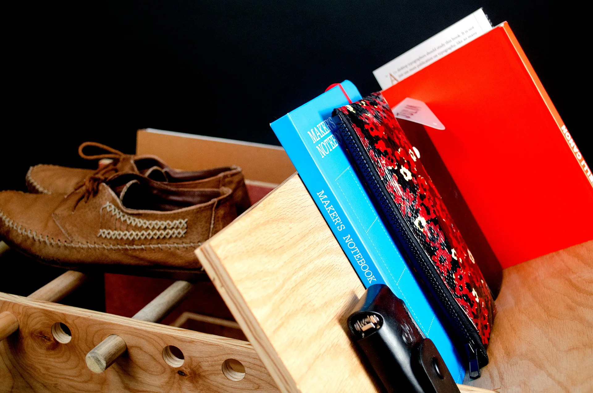 Wooden shelf with a pair of shoes and notebooks