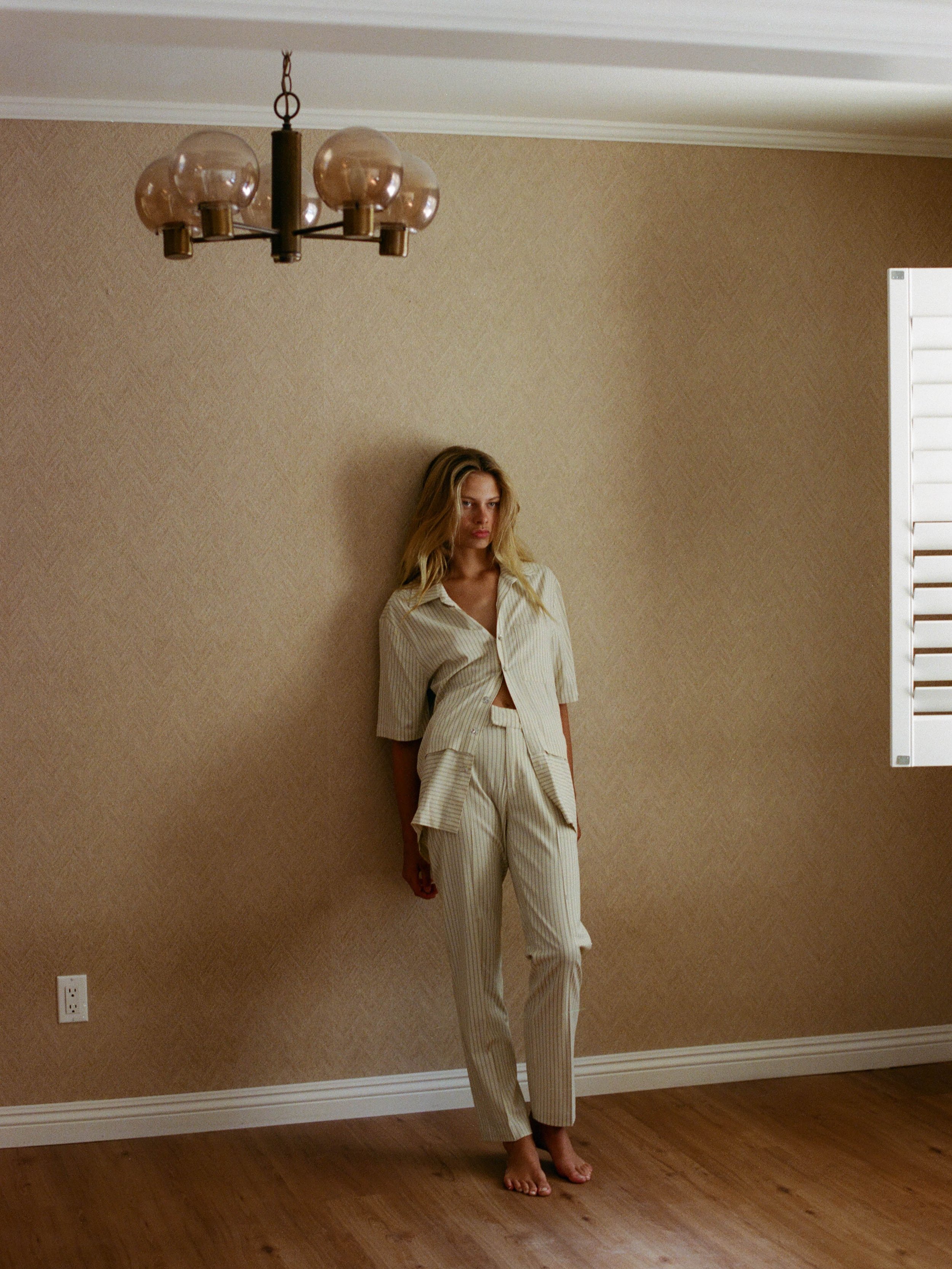  Model shot  with striped matching set against brown wallpaper. Styled by Emily Burnette. 