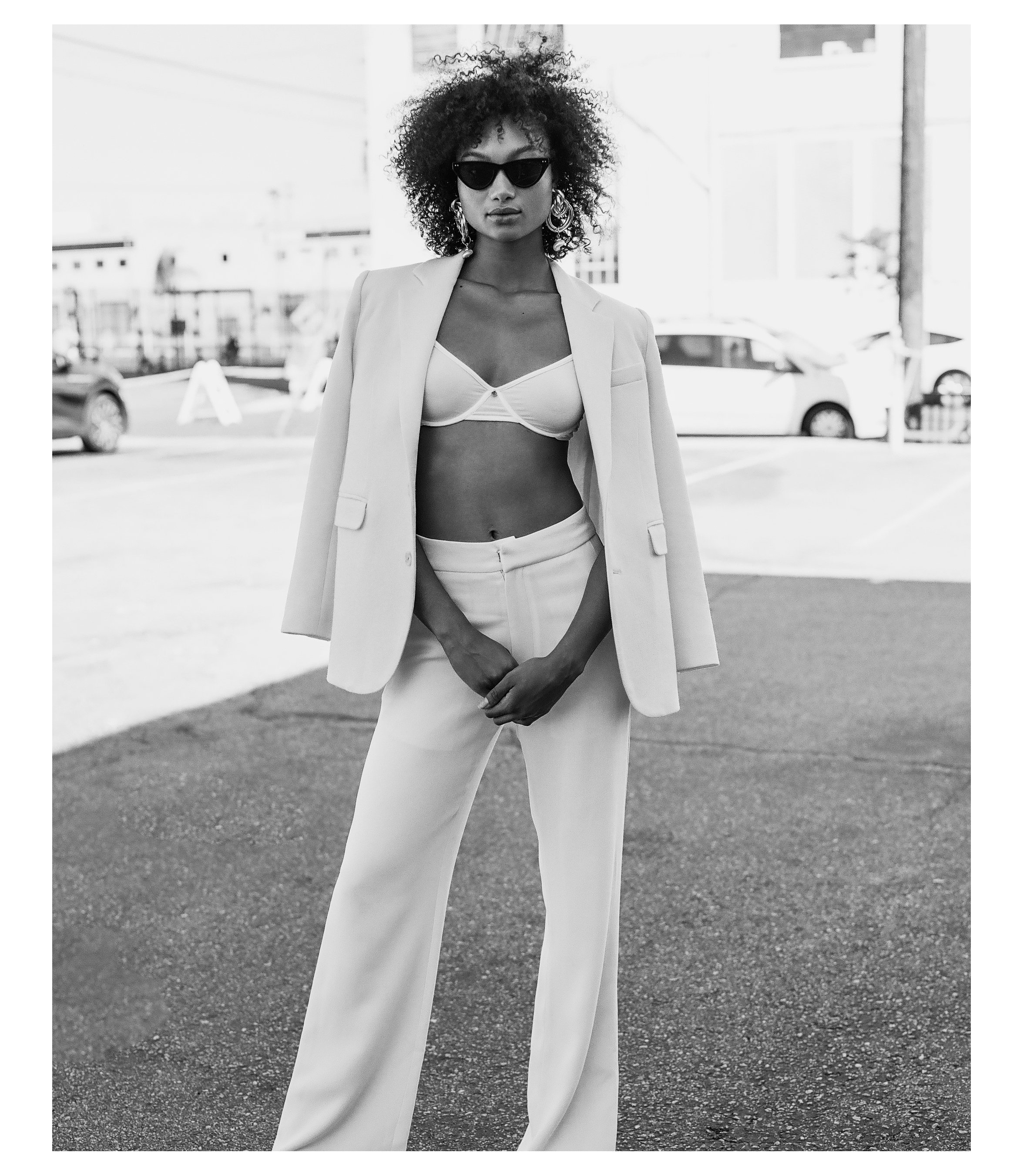  Model shot in black and white styled with cat eye sunglasses, and white suit. Styled by Emily Burnette. 