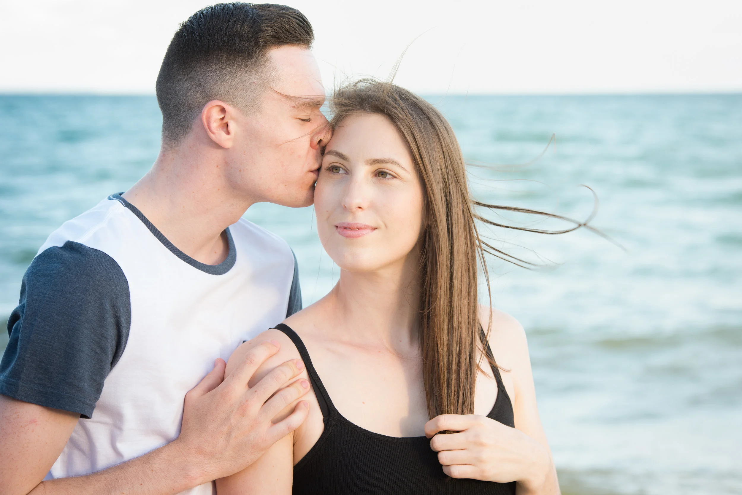 young engaged couple with ocean background
