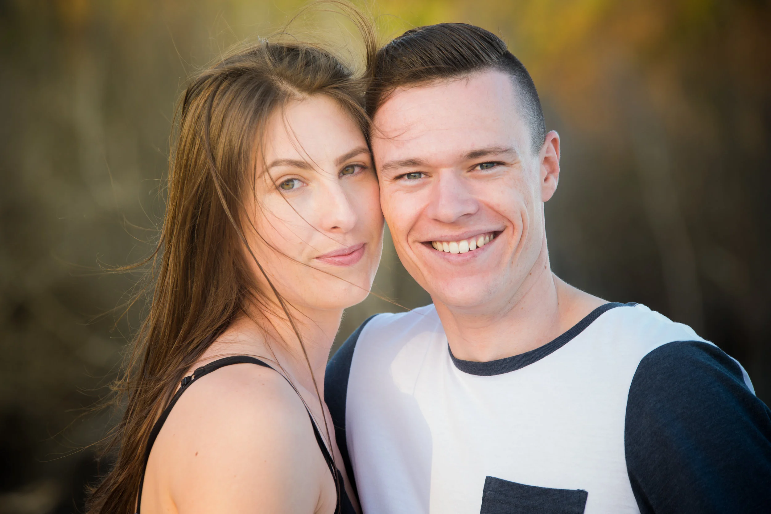 young engaged couple with blurred nature background