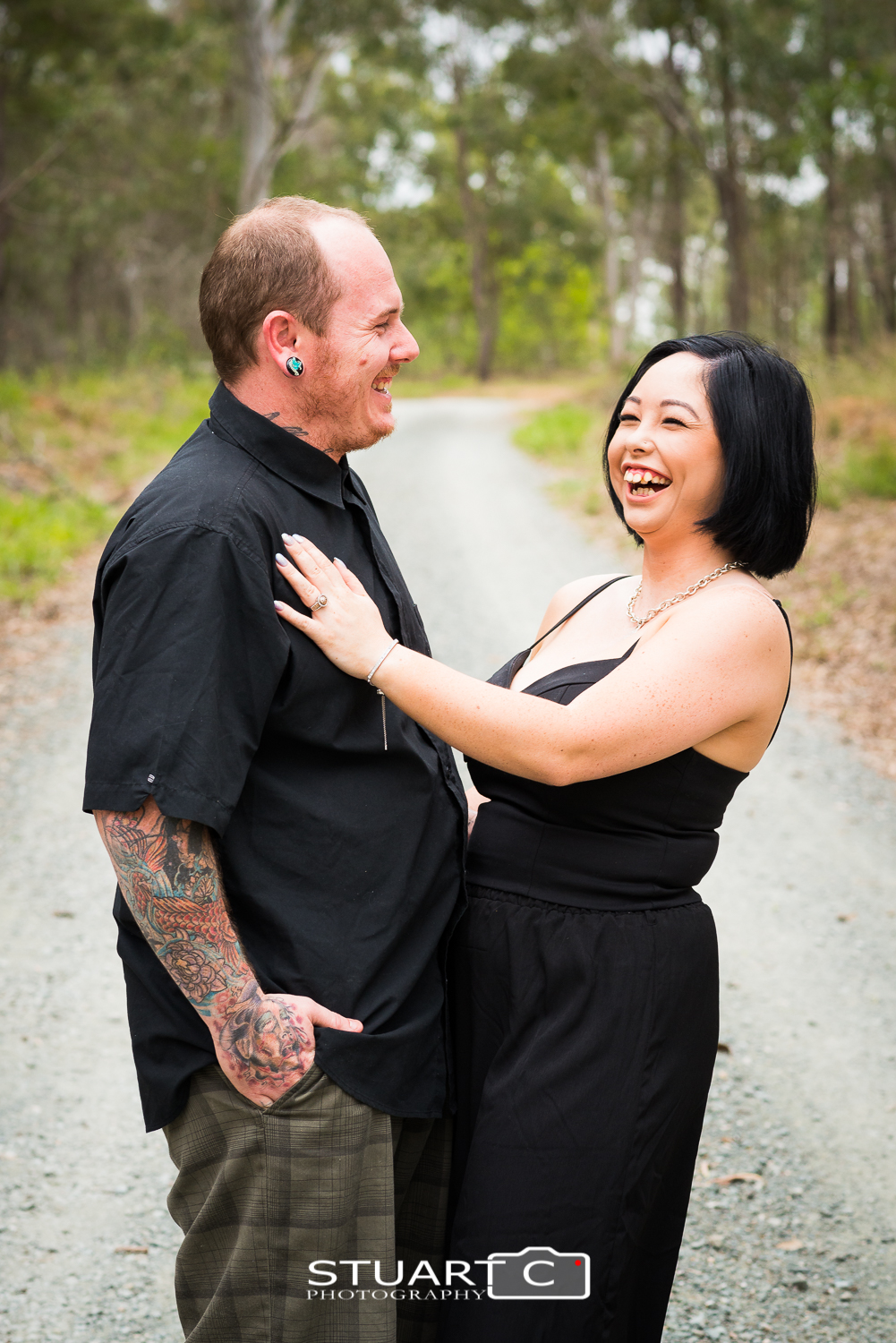 engaged couple standing on dirt road in bushland setting