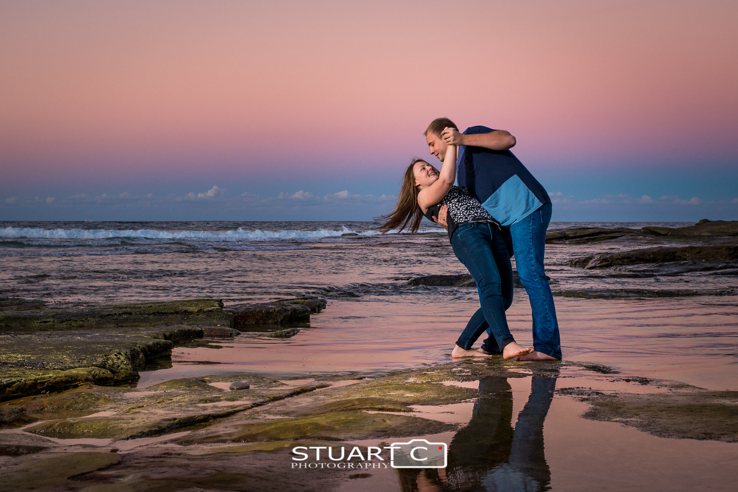 engaged couple dicky beach rocks sunset with flash