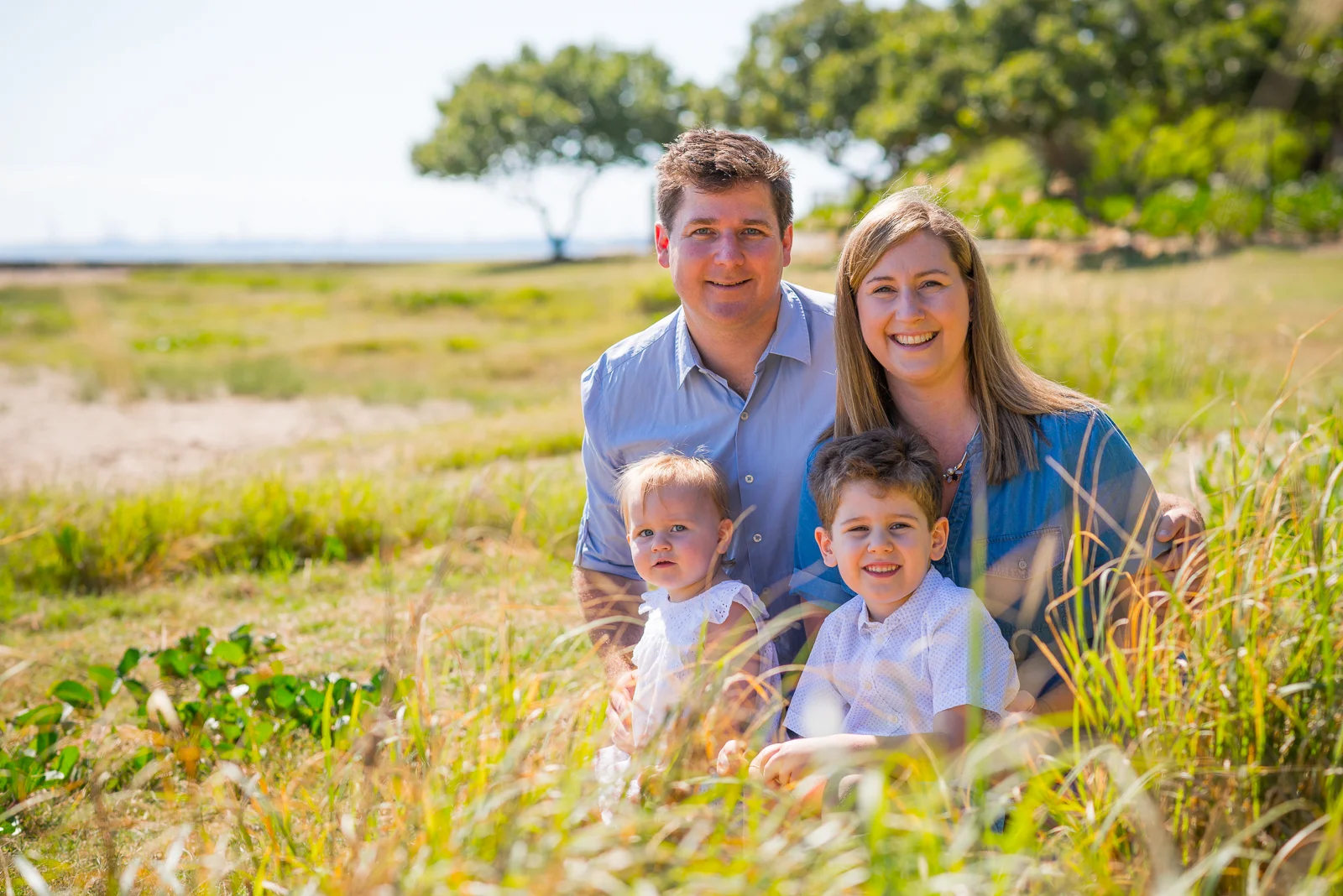 Portrait of Family of four sitting in long grass at Shorncliffe Pier