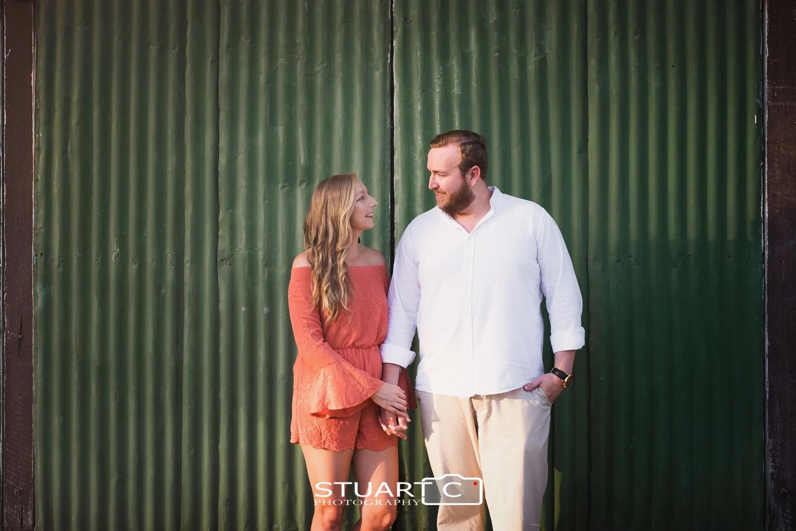 Urban Rustic Portrait of newly engaged couple Jannika and Matt in front of a green tin wall near the main street of woodford