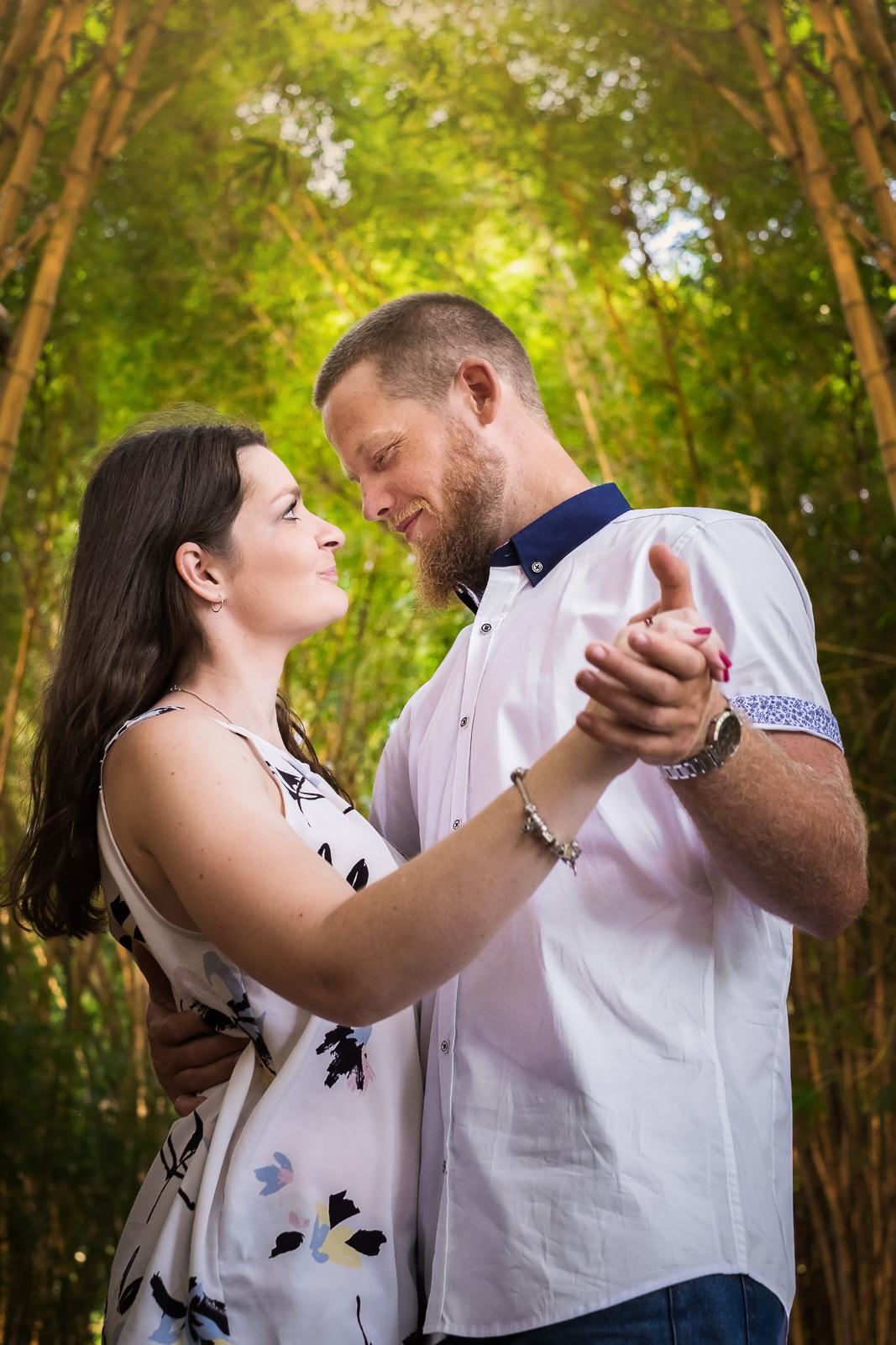 Engaged couple wearing white and blue complimentary shirts for portrait session in gardens