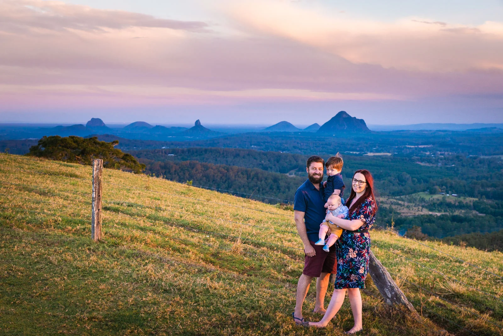 Family portrait at sunset overlooking the glass house mountains from Maleny in teh sunshine coast hinterland