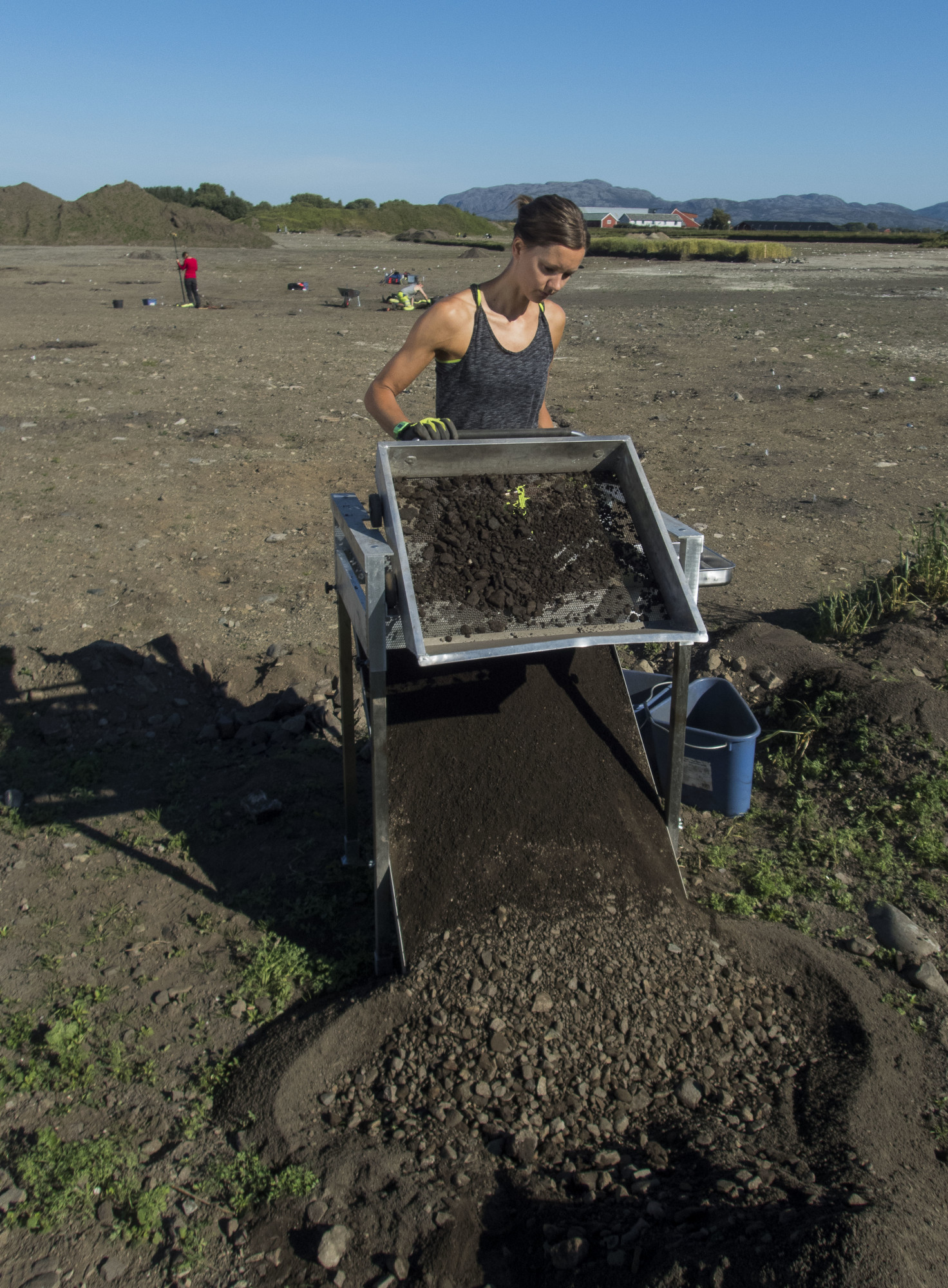 "Synne H. Rostad operates a standing sieve to sift out smaller bones and objects from the dirt." Photo by Åge Hojem, NTNU University Museum, via Gemini press release.