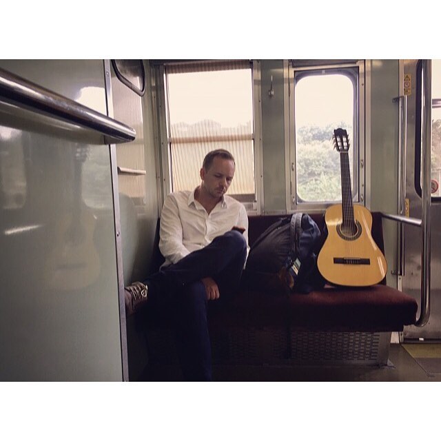 Payne on a train. En route to Tottori, Japan. Prepared with our consignment store guitars for any spontaneous performance that might occur.