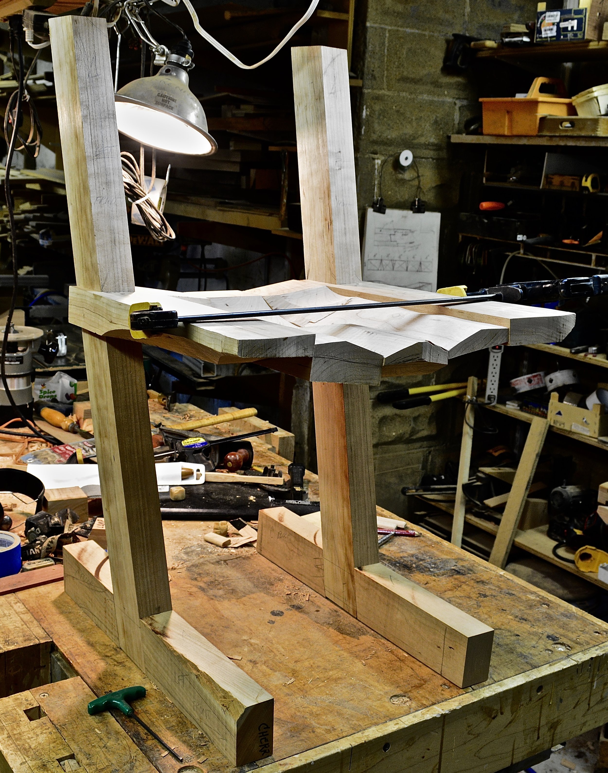 I've bandsawn the rough shape of the seat, the leg - seat joint has been fitted, and the leg-foot bridle joint has been fitted. Now I take it apart (again,and again, and again), bandsaw the rough shape of the legs and feet and glue up the seat.