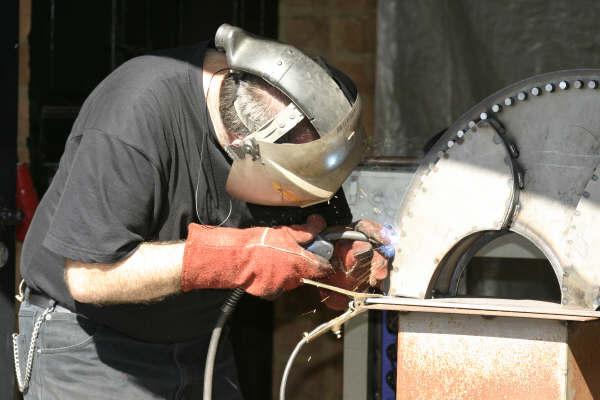 Het werken aan een metalen object "Stier" tijdens de kunstmarkt in Catsop Elsloo. (winandusmarkt)