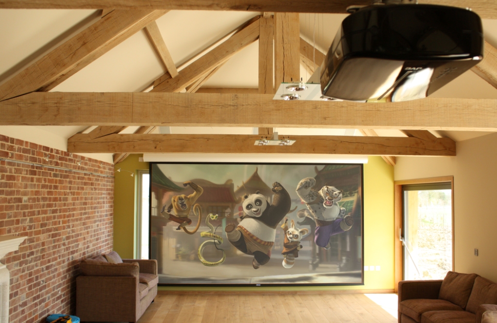 Projector based cinema system with motorised screen and Bowers & Wilkins speakers.