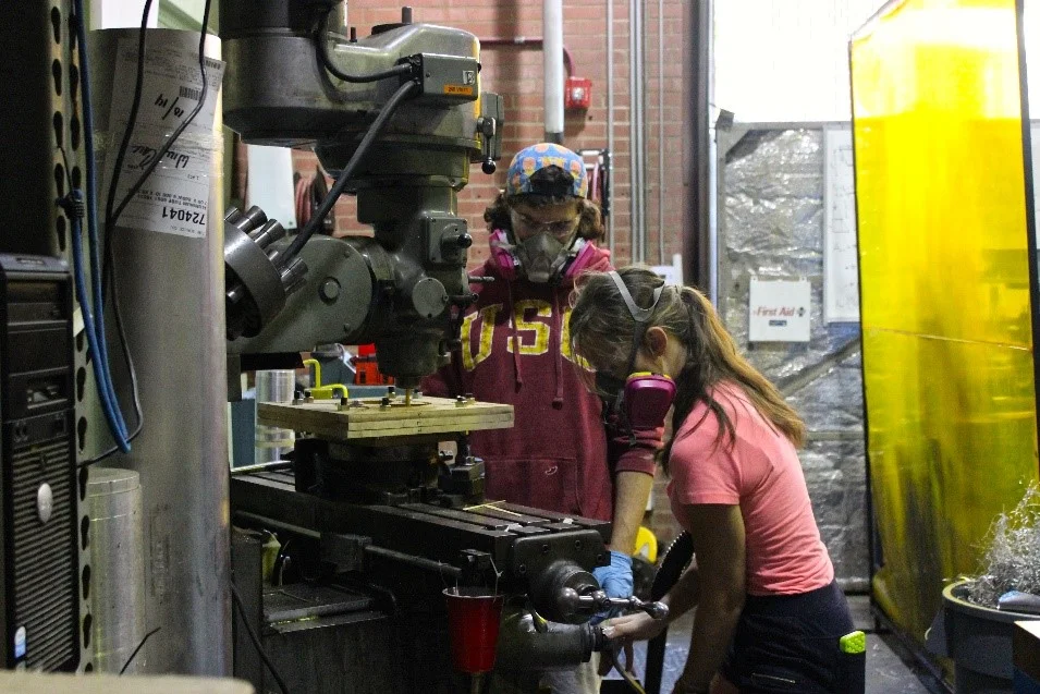 Feargus and Skye machining the fin alignment tool on the mill.