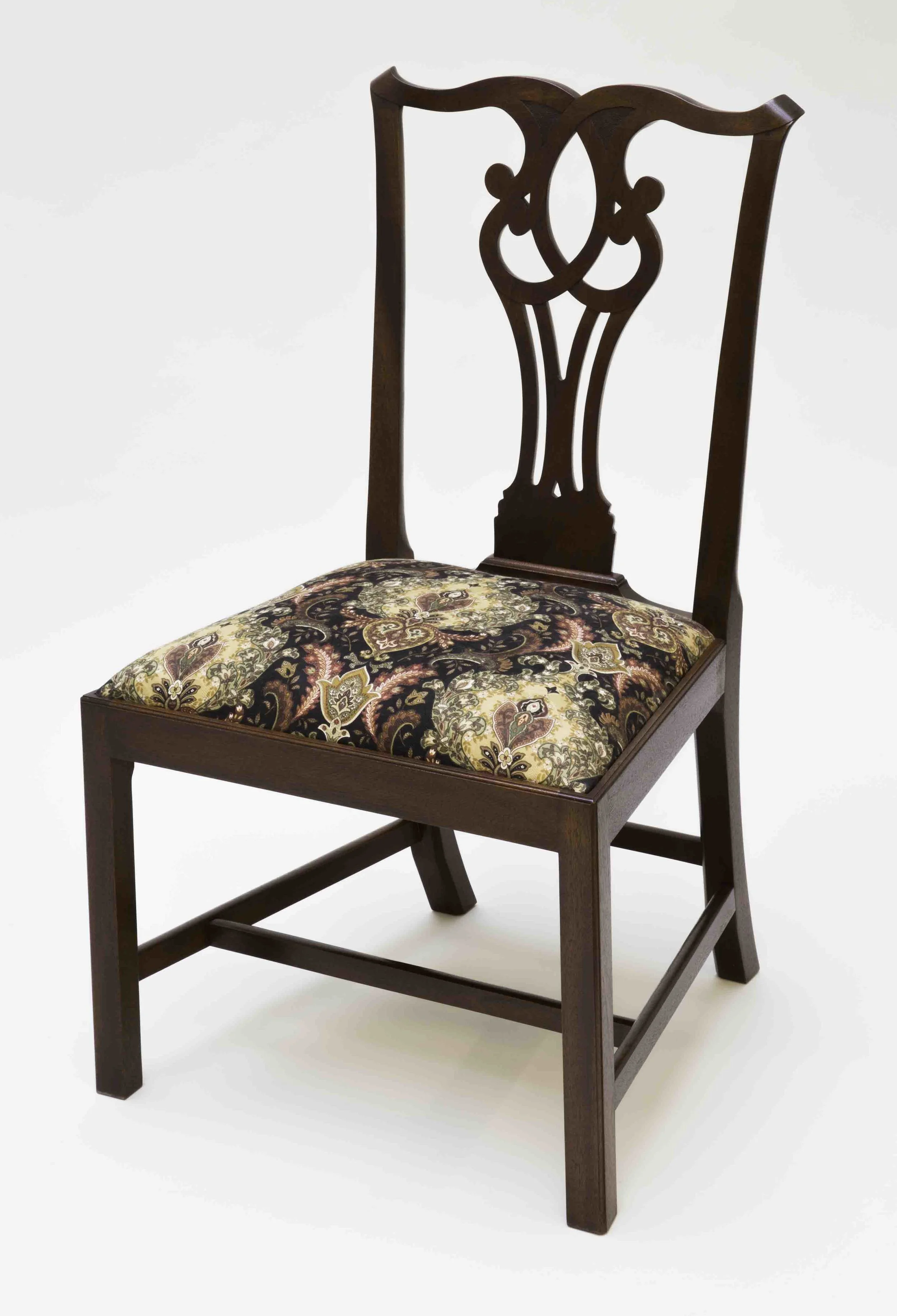 This is a Chippendale side chair. The chair frame is mahogany, slip seat frame is ash, glue blocks are pine. Muslin, horse hair, two inch webbing, black cloth and cotton stuffing are used for the slip seat cushion. A formula of orange dye, brown walnut dye, brown walnut pigmented stain were used to achieve the rich color. A shellac was applied by hand (French polish). This chair is for sale for $1800.00. Dimension: 21 1/2" wide x 38" high x 17 1/2 deep. (Click on the picture to see how it was put together.)