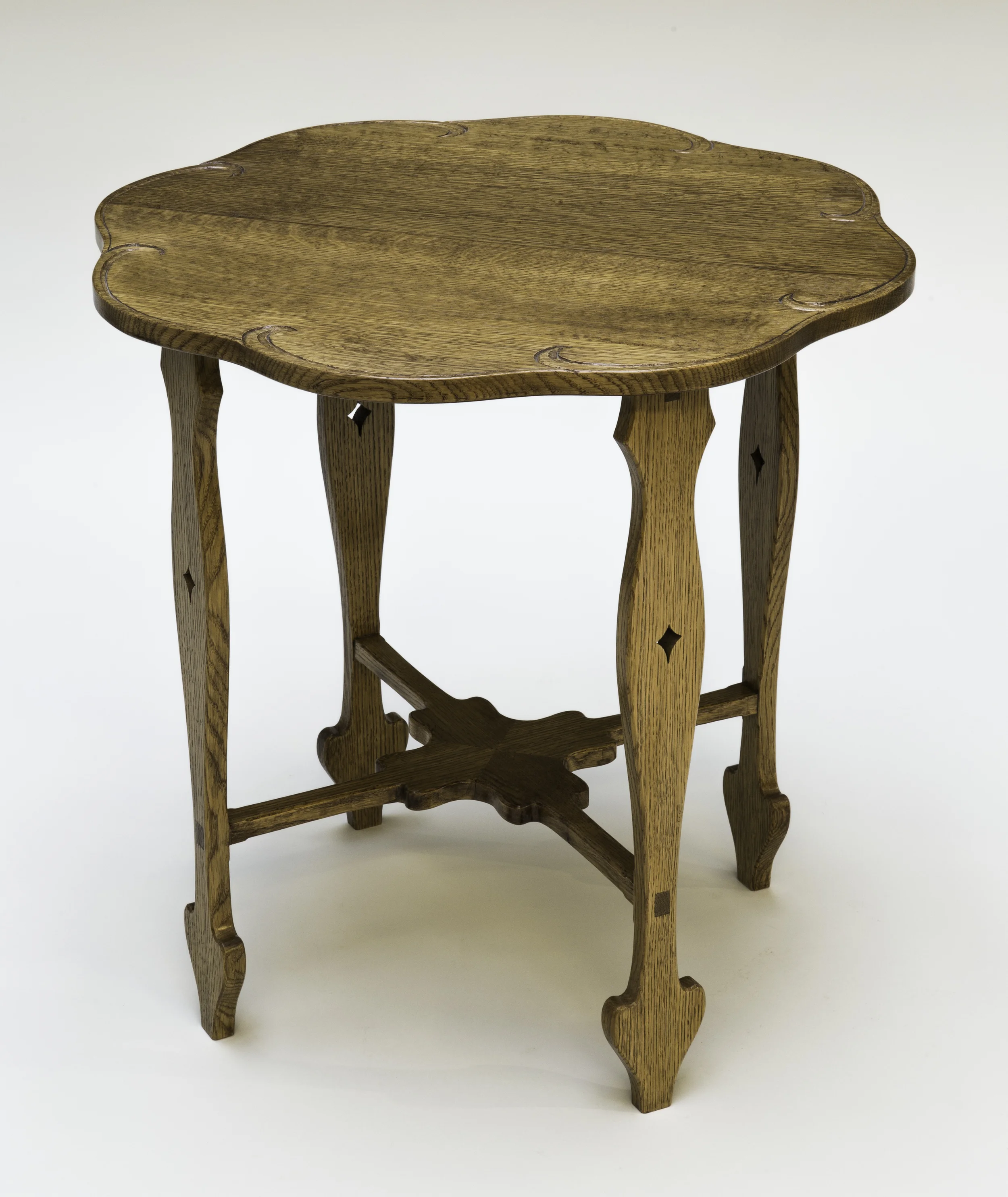 This piece is based on a Charles Rohlfs table. An interesting feature of this table is the bottom stretcher, which is mortised and tenoned into the legs. The stretchers are joined to each other with a mitered half lap joint. Quarter sawn white oak is the wood used for this table. Blonde and amber shellac was used to even out the wood color. Brown glaze was applied to highlight the grain and to give the table an aged look. An oil and urethane finish was used for a top coat. You can purchase this table for $600.00. Dimension: 24" diameter x 24" high (Click on the picture to see how it was put together.)