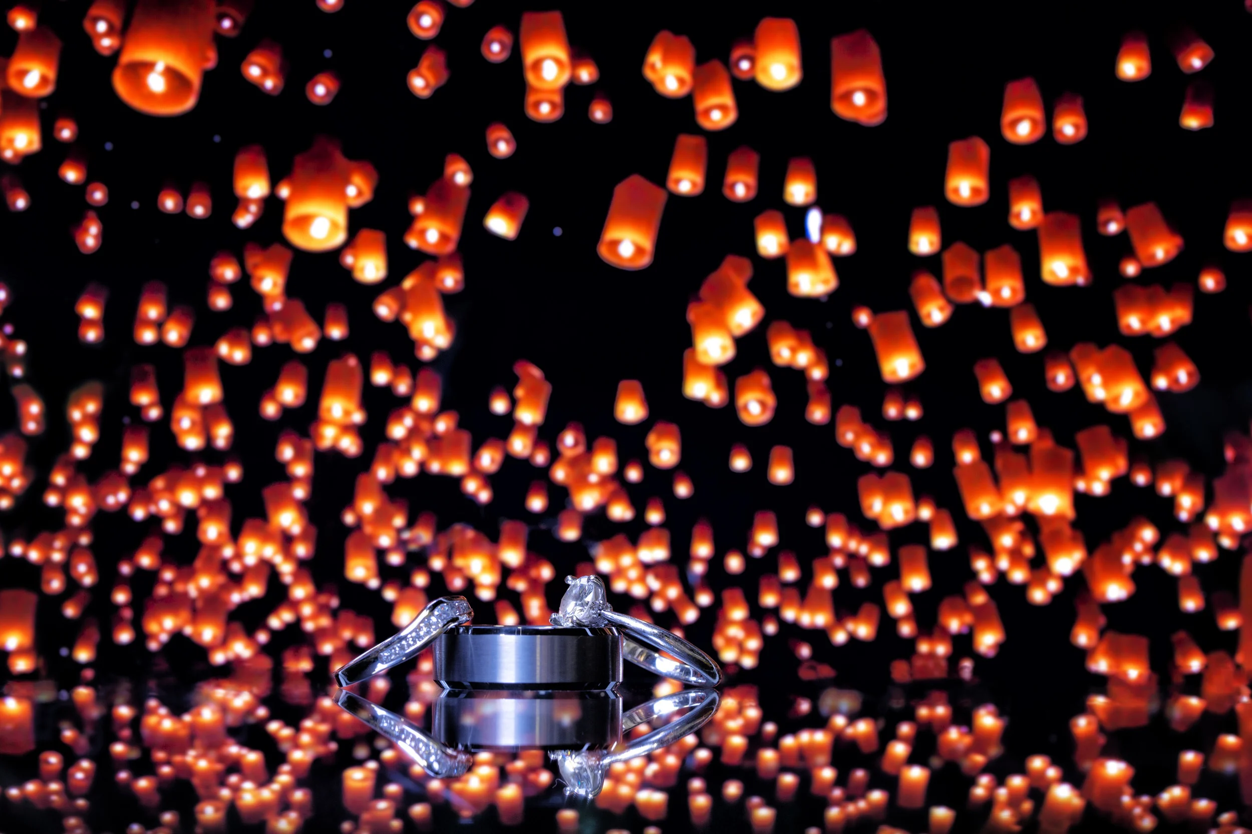 The symbols of the couple's love with a backdrop of the paper lantern lighting ceremony, where the groom proposed to his bride when they were on vacation.