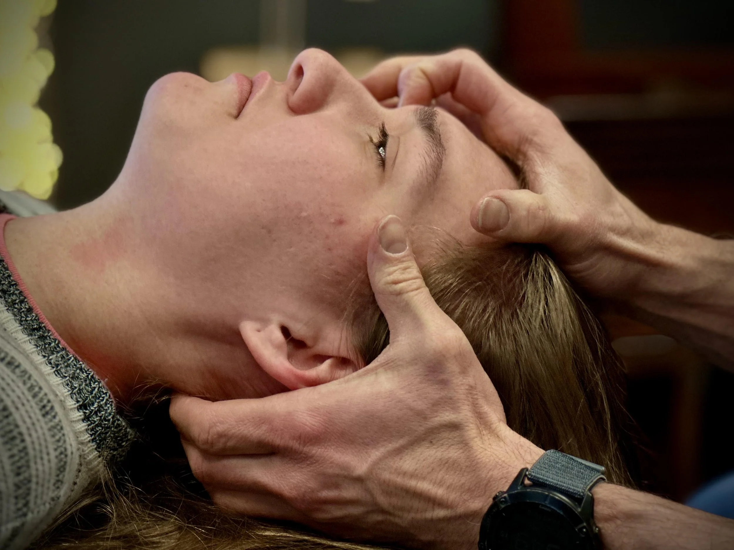 Person receiving chiropractic neck adjustment from a chiropractor.