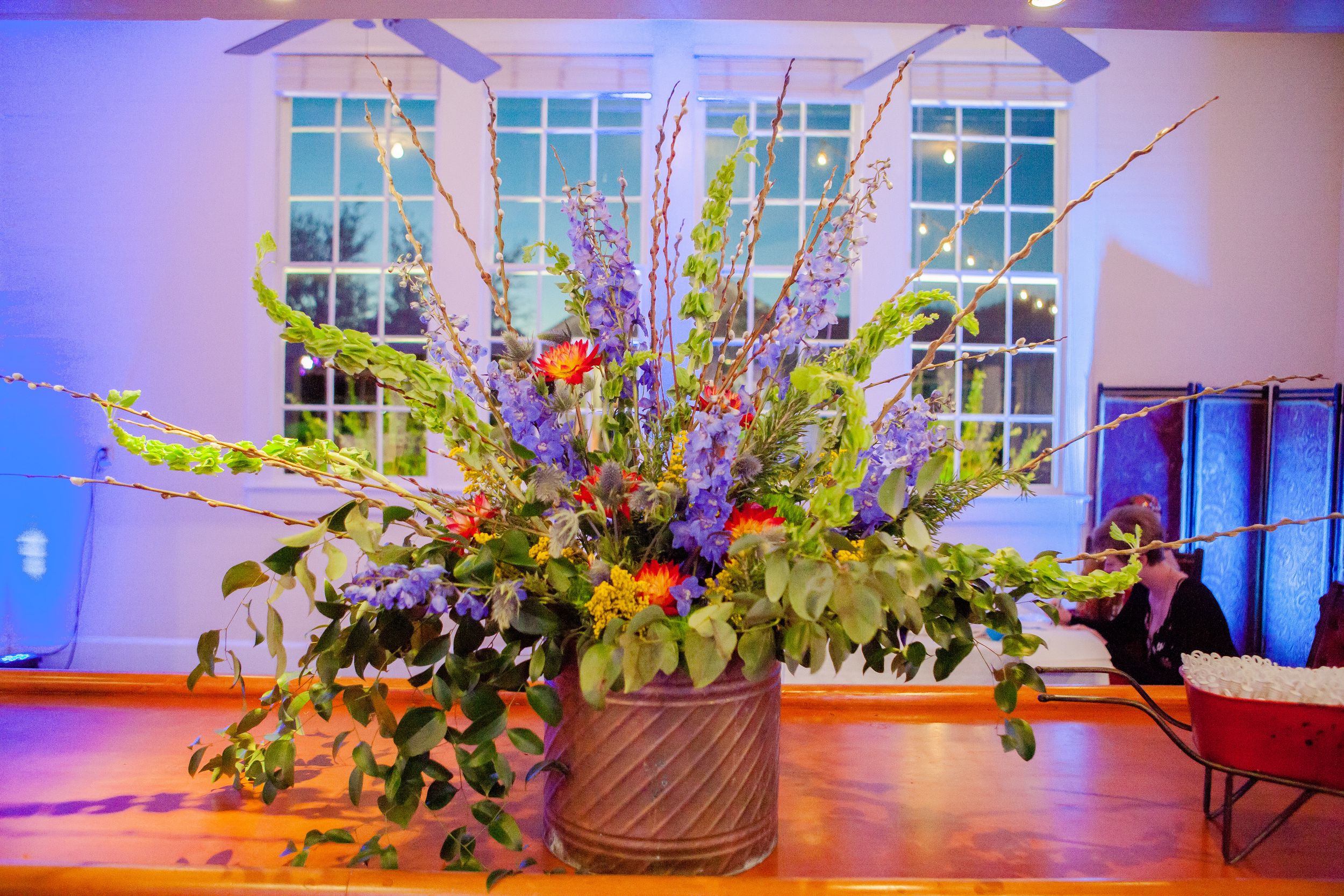 Bar top piece in the dance hall including Dahlias, Delphinium, Bells of Ireland, Smilax, and Pussywillow.