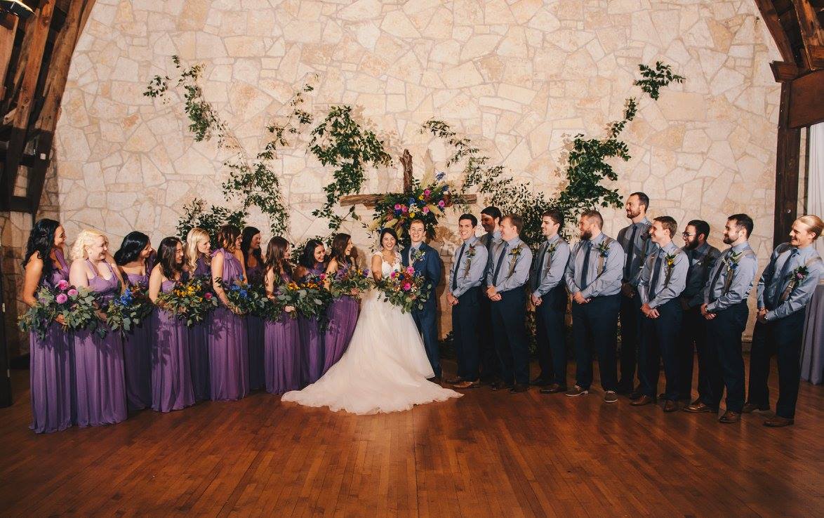 With such a large wedding party, the coordination of bouquets and boutonnieres is a bit more complicated. Each member's personal flowers were reflected directly in the bride's bouquet, creating a visual connection. Photo credit: Kat/Eye Studios