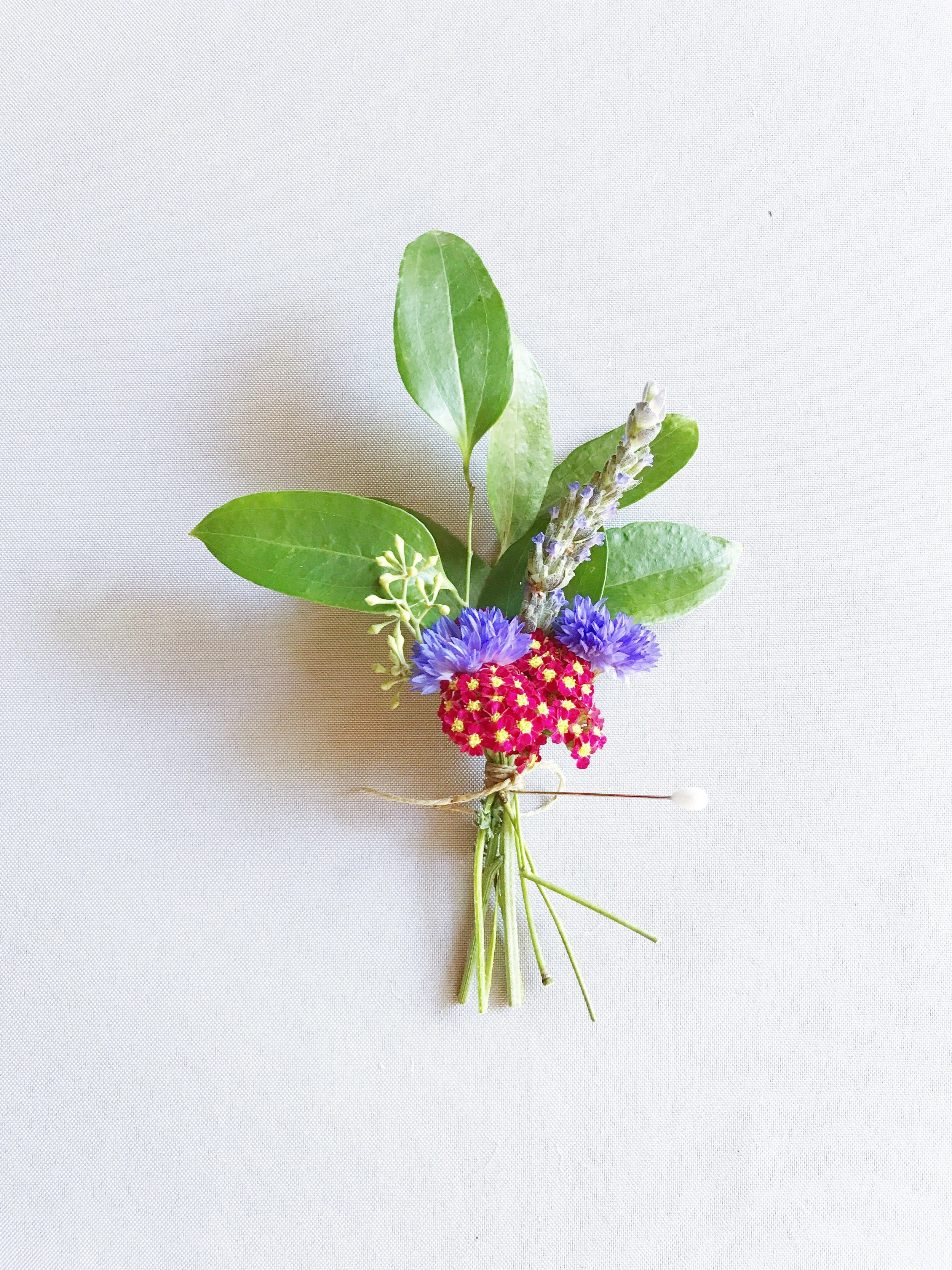 Smilax, seeded eucalyptus, red cottage yarrow, cornflower, and lavender composed some of the family's boutonnieres. 