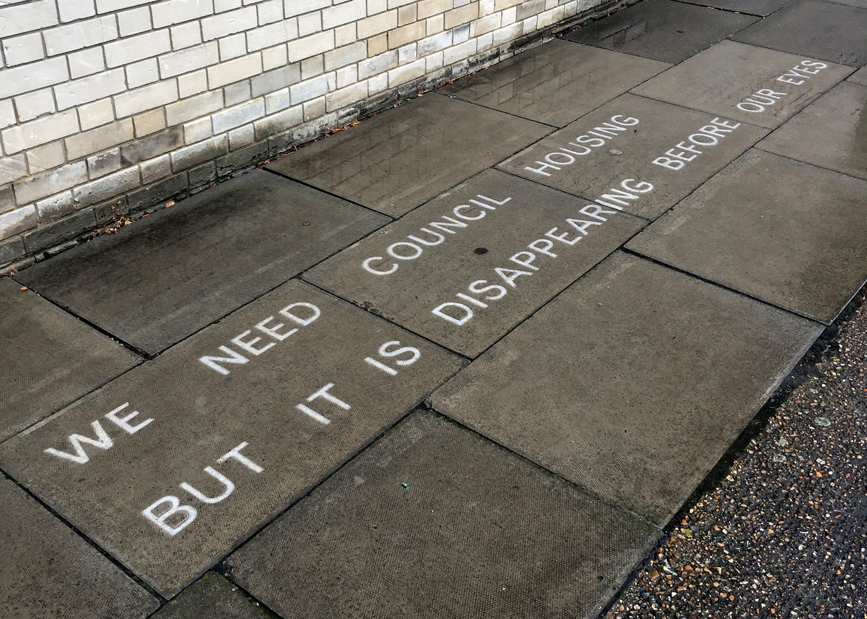 We need council housing but it is disappearing before our eyes (2017), text in water-repellent spray (words by Susan), temporarily sited on Pelican Estate.