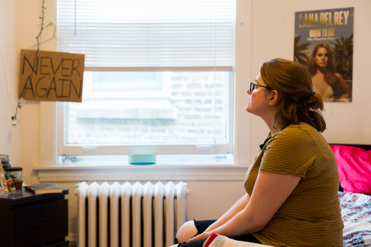 Haggerty sits in her bedroom across from her 'NEVER AGAIN' sign. The sign symbolizes the era before Roe v. Wade when women resorted to coathanger abortions to end unwanted pregnancies. Haggerty made the sign for the "March for Lies," a counter protest to the Illinois March for Life in Chicago.