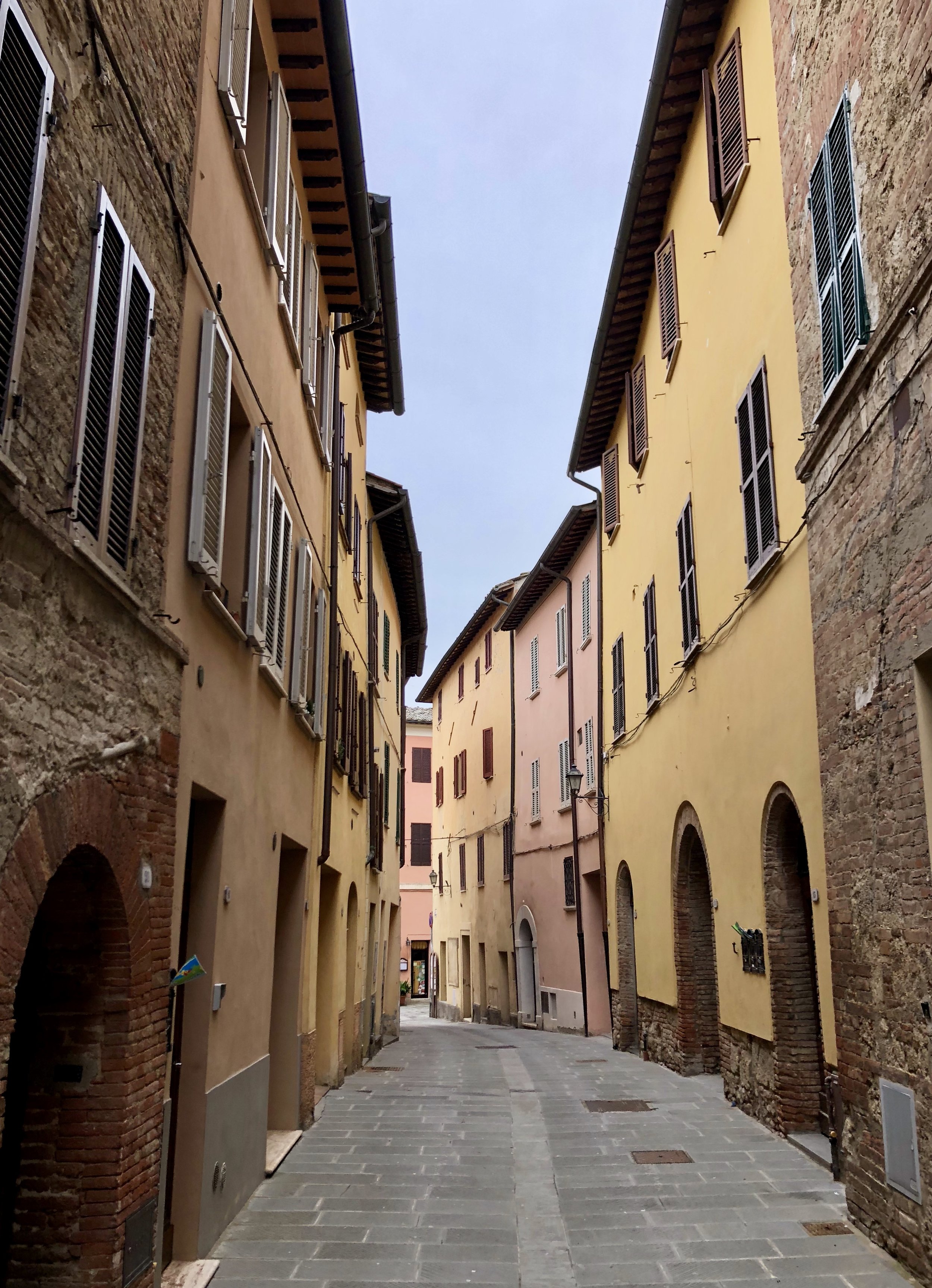 Street view: Entrance is the first arched doorway on the right, in the yellow building.  