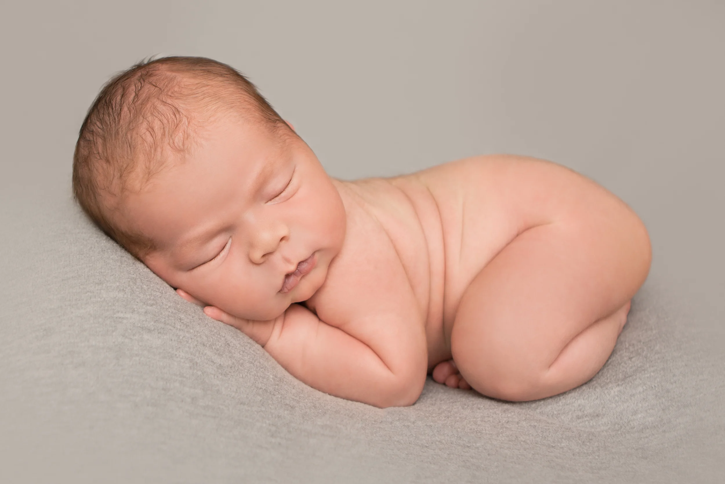 Newborn baby boy chubby, on grey gray fabric backdrop bean bag pose, Westchester County, New York newborn photographer, Amanda Noelle Photography.