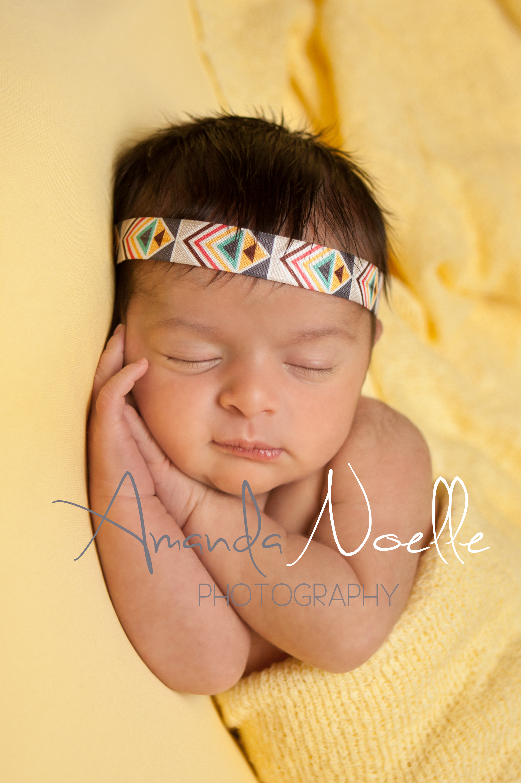 Newborn baby girl sleeping with bohemian aztec headband wrapped in yellow stretch knit wrap on yellow fabric backdrop, beanbag pose, Westchester, County New York Newborn Photographer, Amanda Noelle Photography.