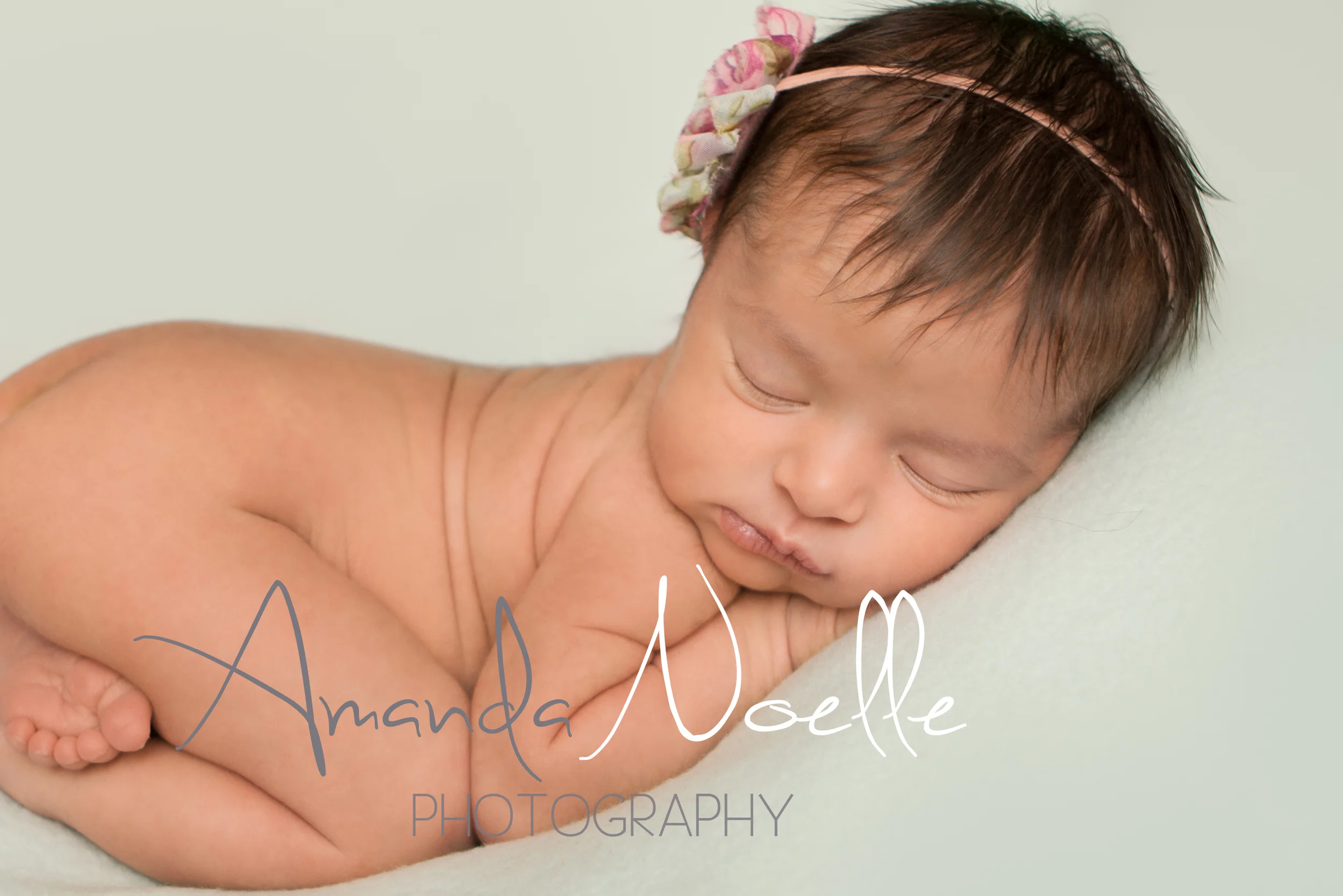 Newborn baby girl sleeping with shabby chic pink headband on teal mint aqua fabric backdrop, tushy up beanbag pose, Westchester, County New York Newborn Photographer, Amanda Noelle Photography.