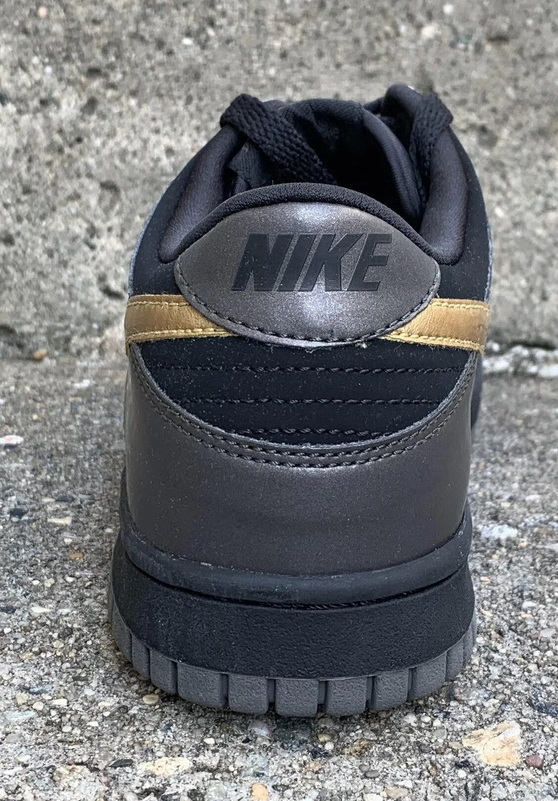 Kids Nike Dunk Low Black / Metallic Gold newsprint.