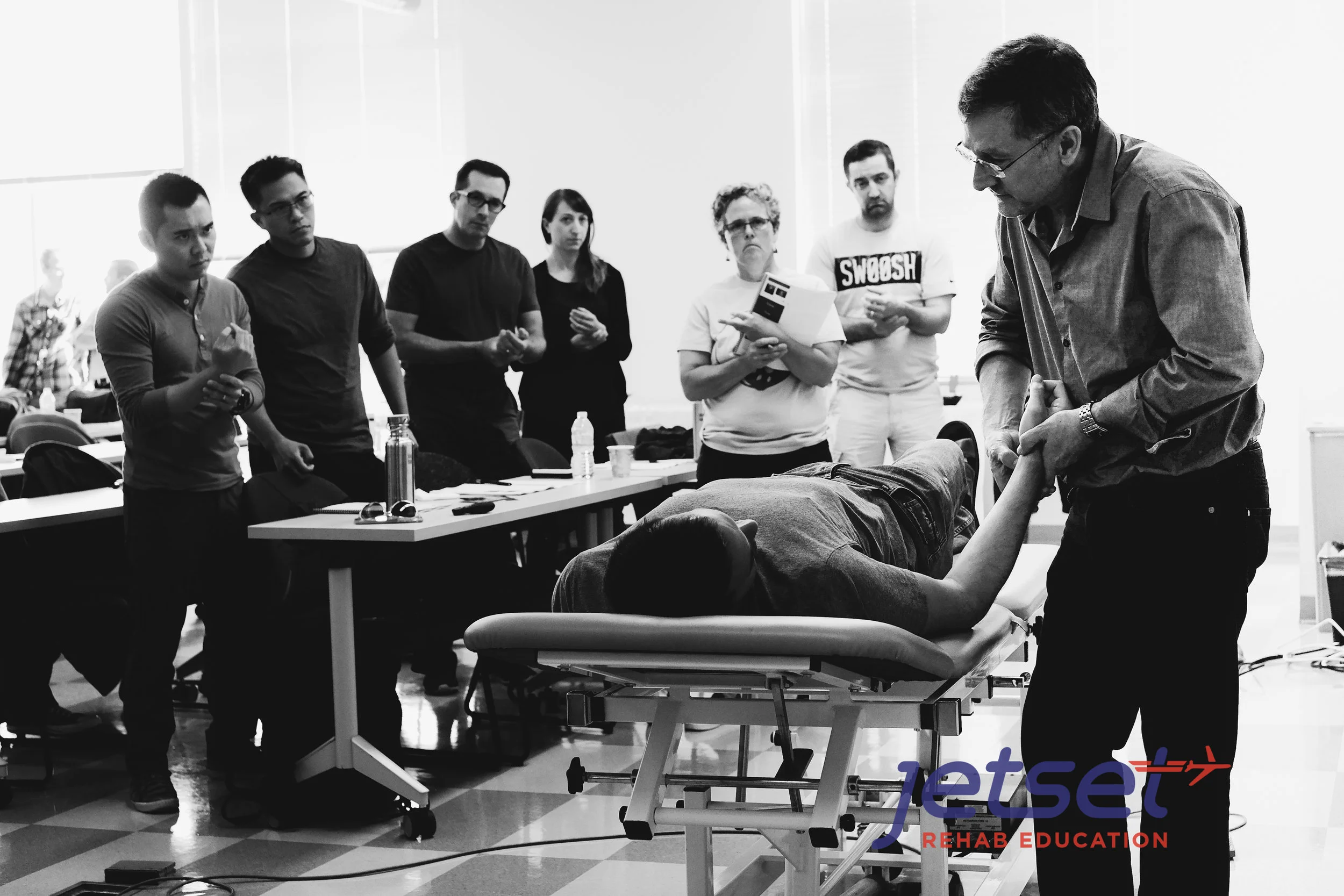 Michael Shacklock demonstrates the palpation of the Median Nerve as students look on.