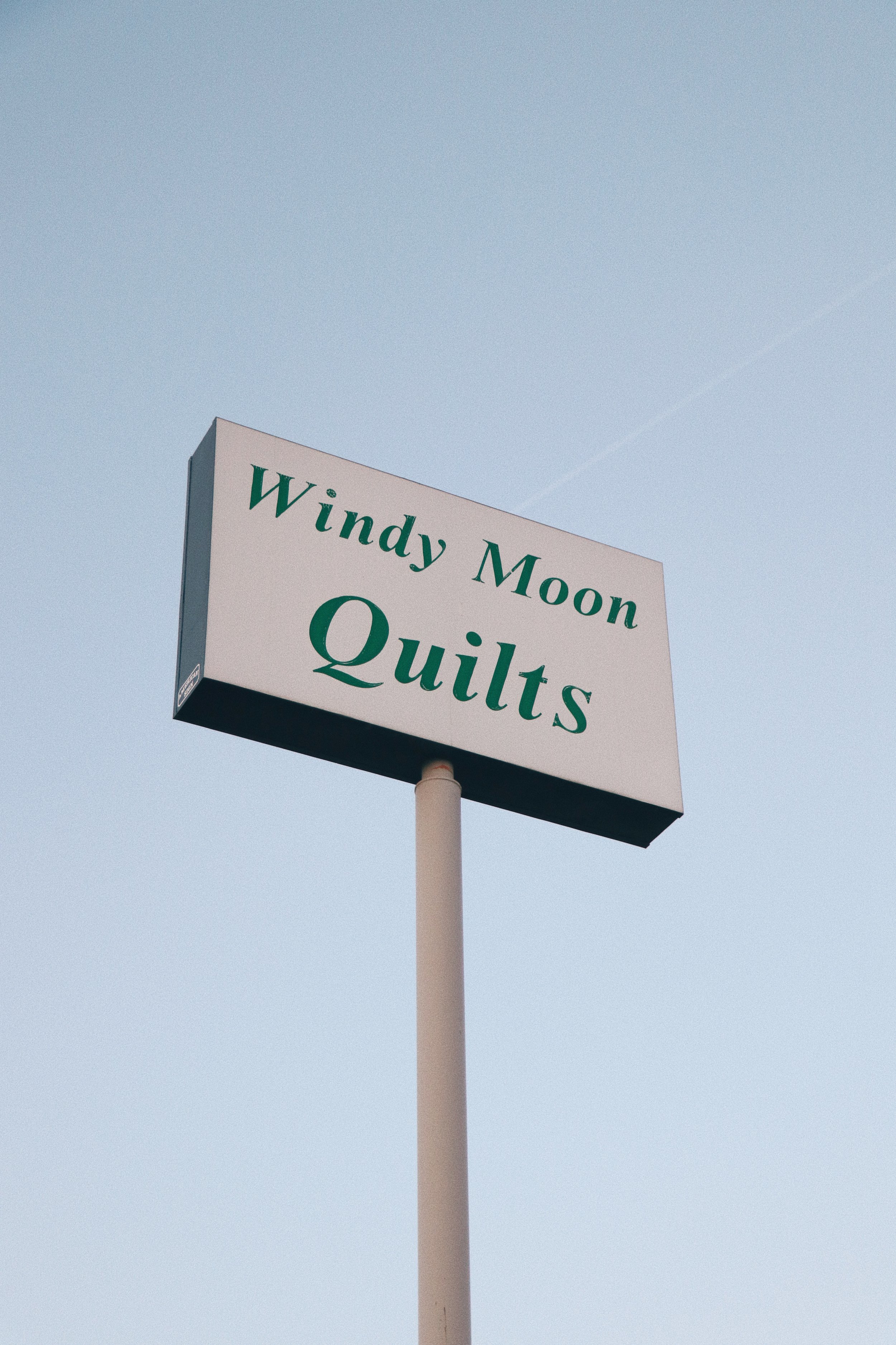 windy moon quilts sign against the sky