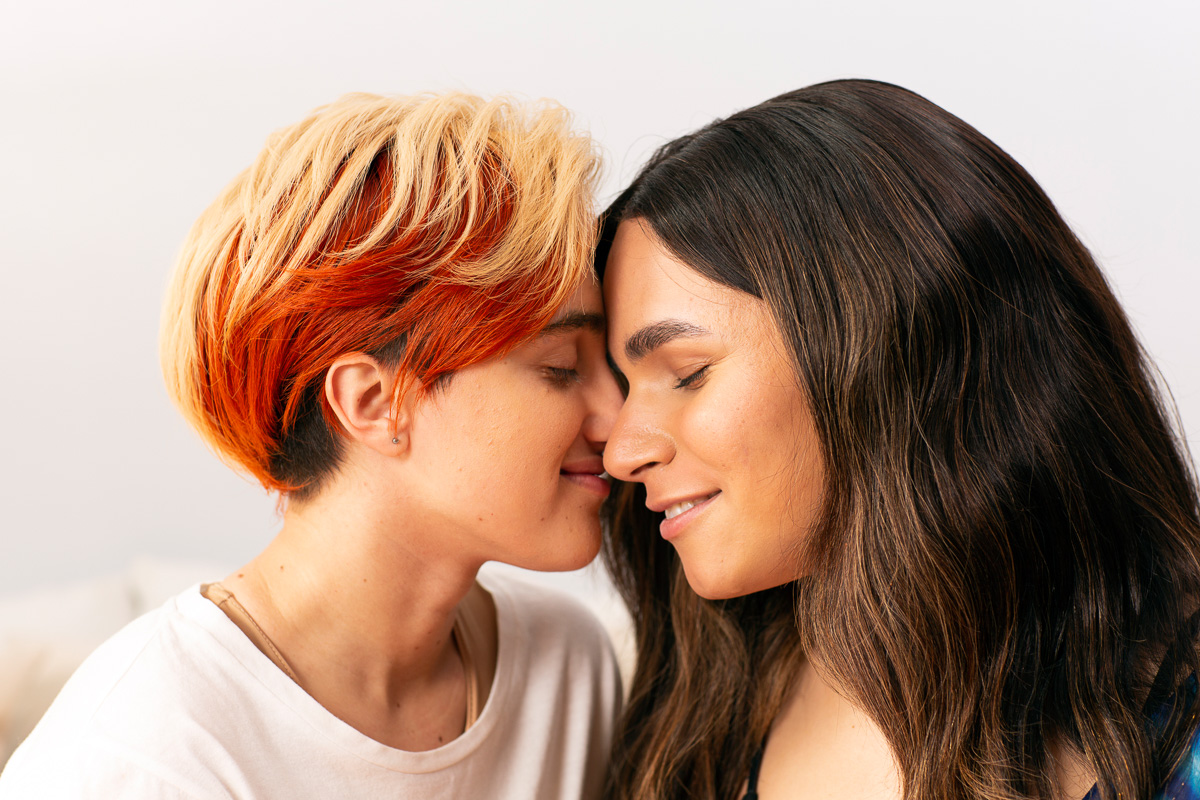 A transmasculine gender-nonconforming person and transfeminine non-binary person nuzzling.jpg