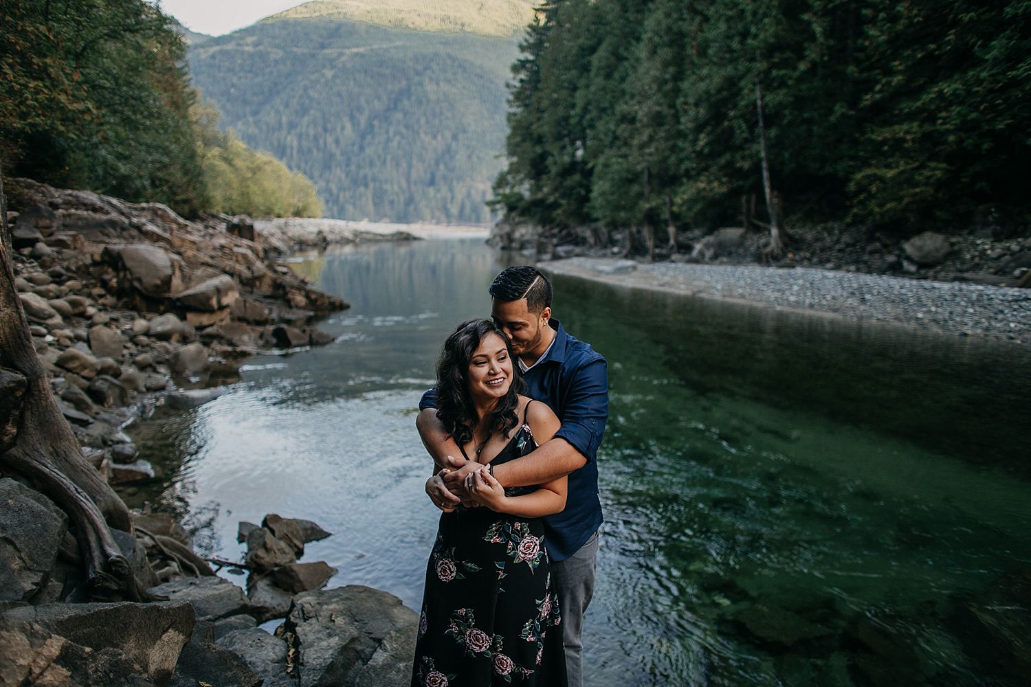 Copy of couple hugging candid moment water trees mountain