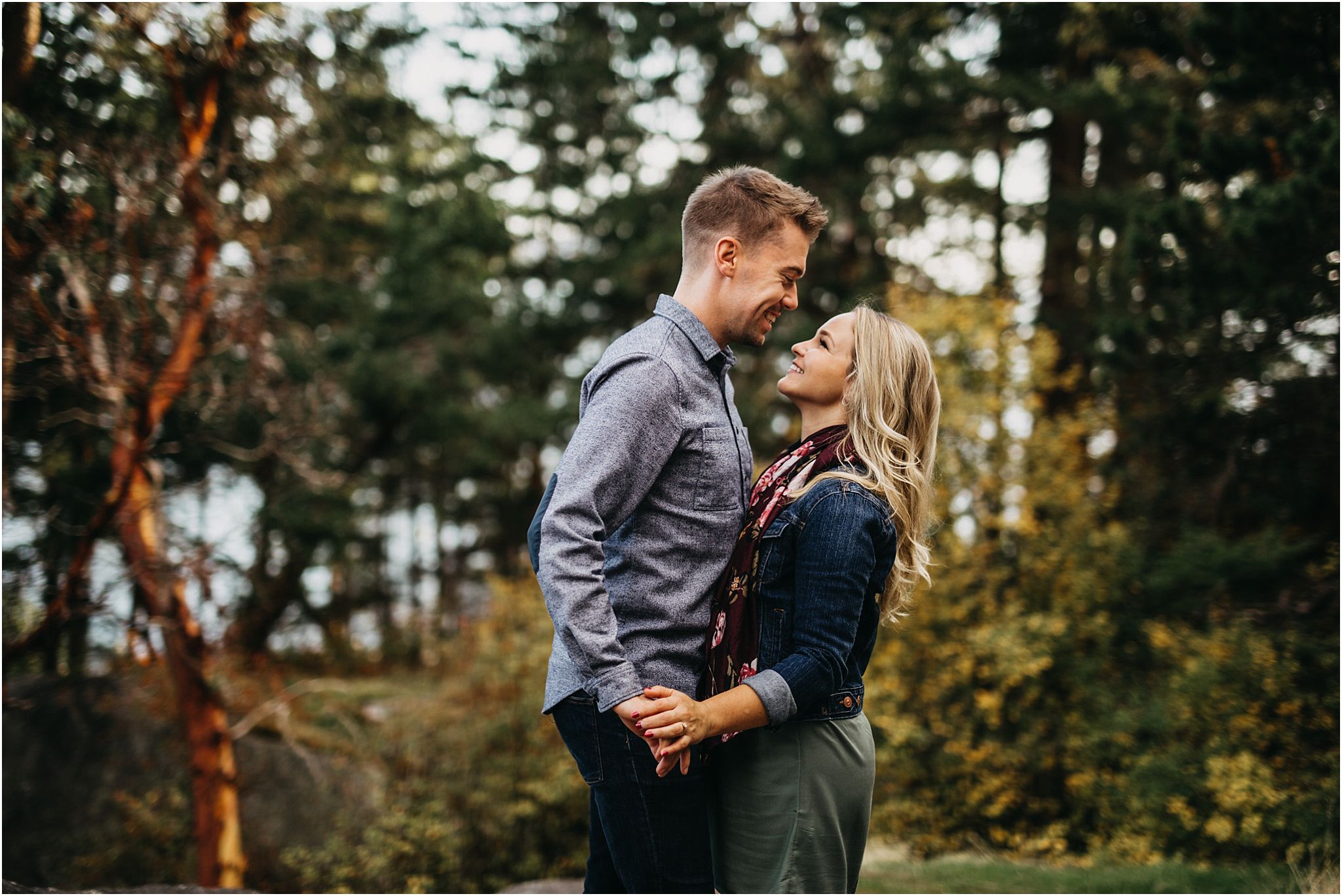 man woman holding hands in forest fall colours